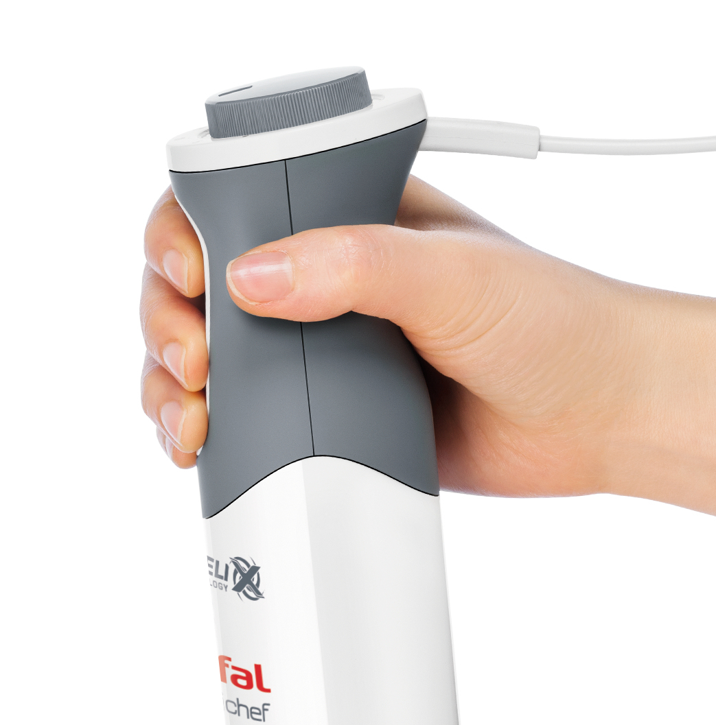 Dłoń trzymająca szary i biały blender ręczny z dołączonym białym kablem.