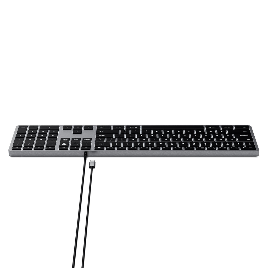 Een toetsenbord met zwarte toetsen op een grijs oppervlak, met een kabel.