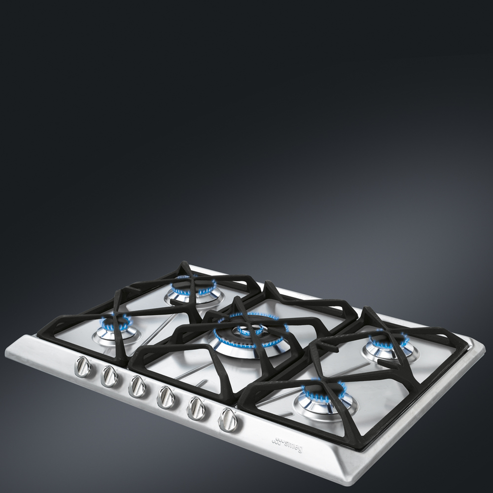 Gazowa płyta kuchenna ze stali nierdzewnej z pięcioma palnikami, niebieskimi płomieniami, na ciemnej powierzchni.