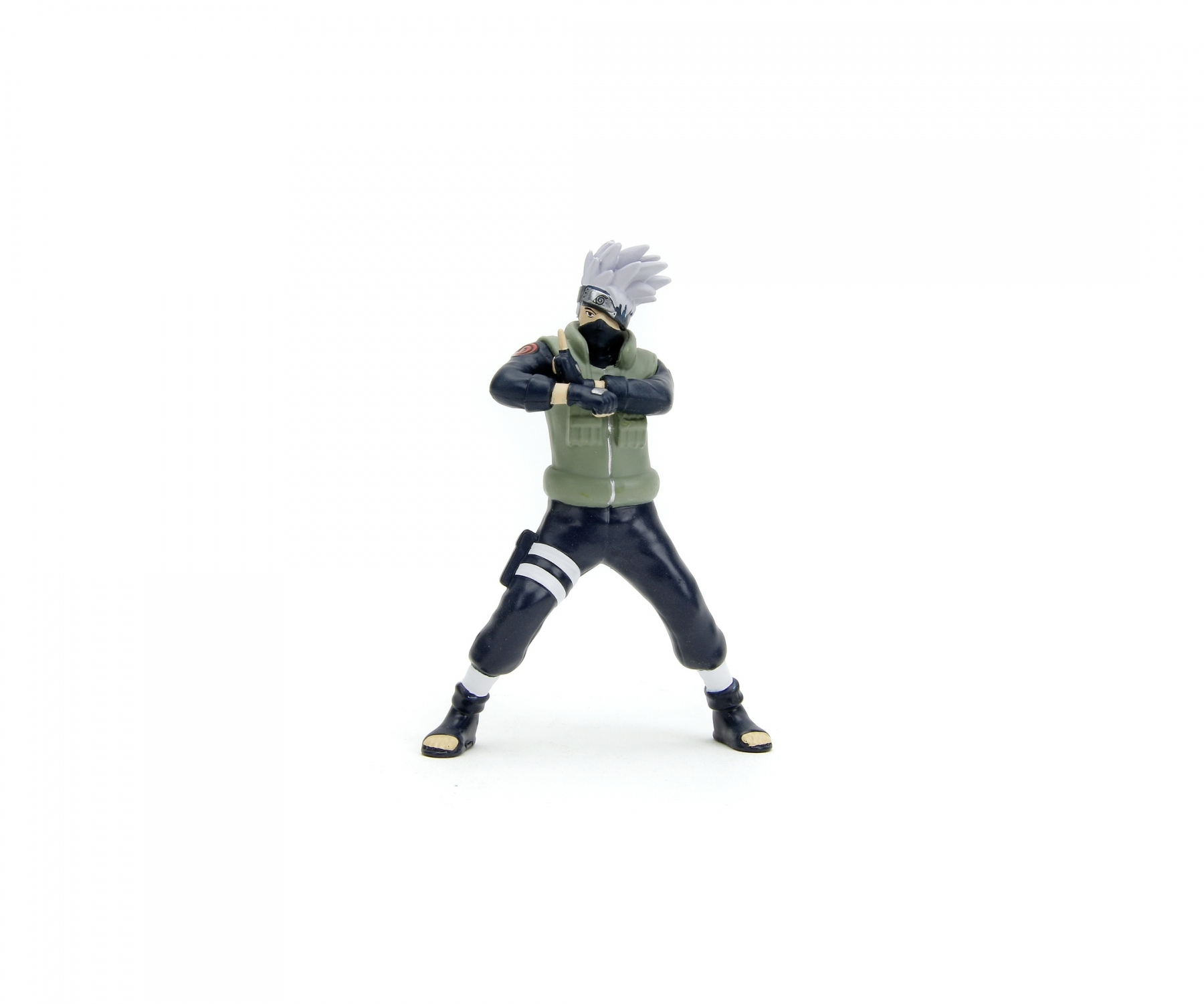 Figurka postaci z Naruto, w zielonej kamizelce i czarnych spodniach, na białym tle.