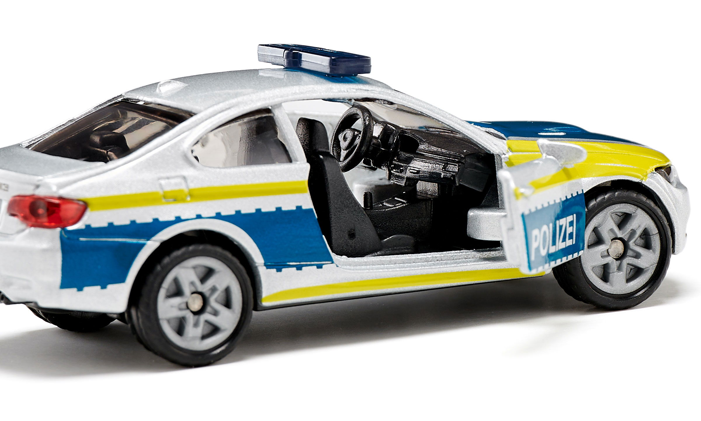 Silbernes und weißes BMW Polizeiauto-Spielzeug. Seitenansicht, mit blauen und gelben Streifen. Offene Tür.