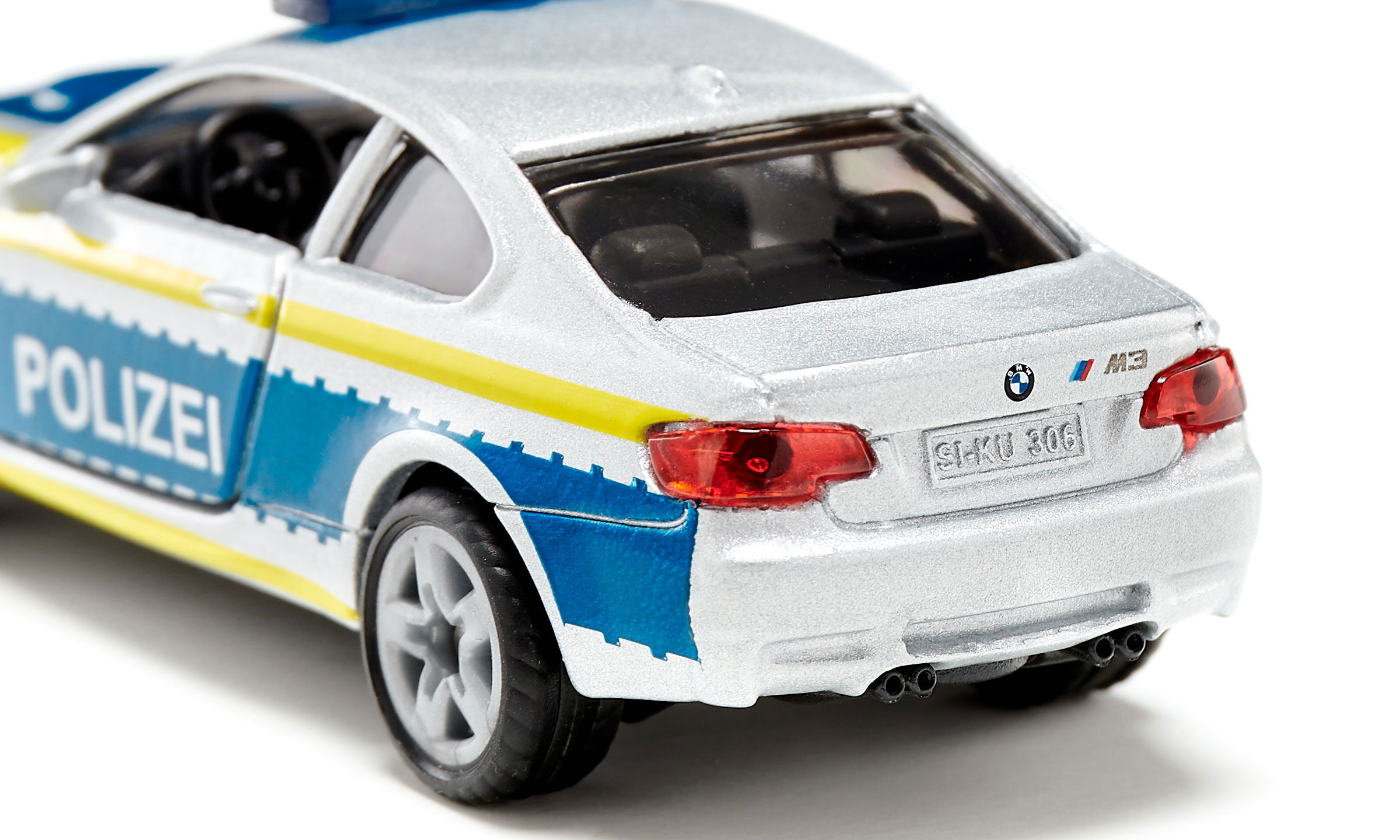 Silbernes und weißes BMW Polizeiauto-Spielzeug. Rückansicht, mit blauen und gelben Streifen.