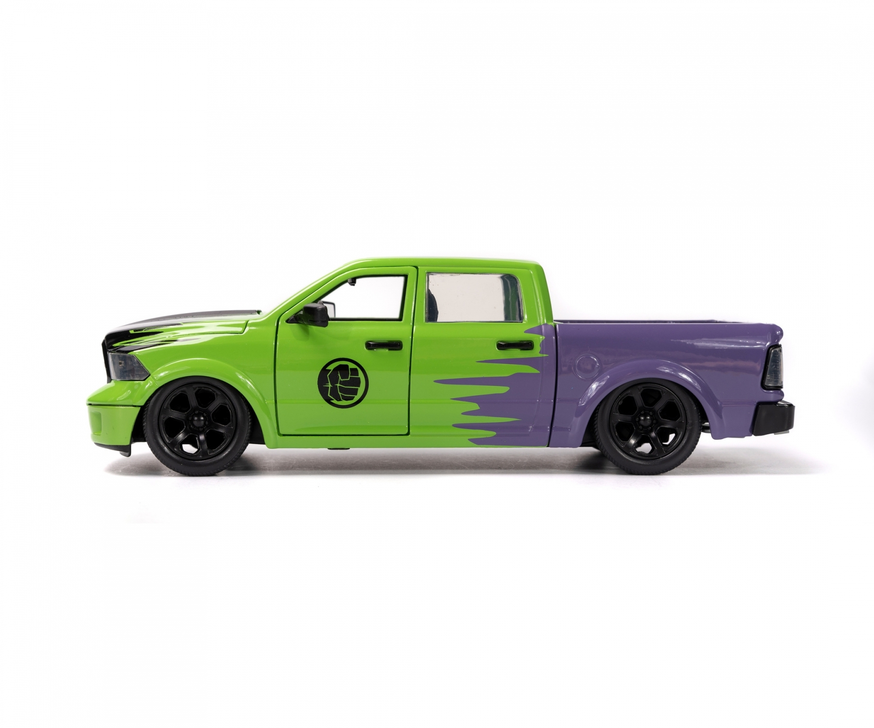Camion jouet vert et violet avec un fond blanc.