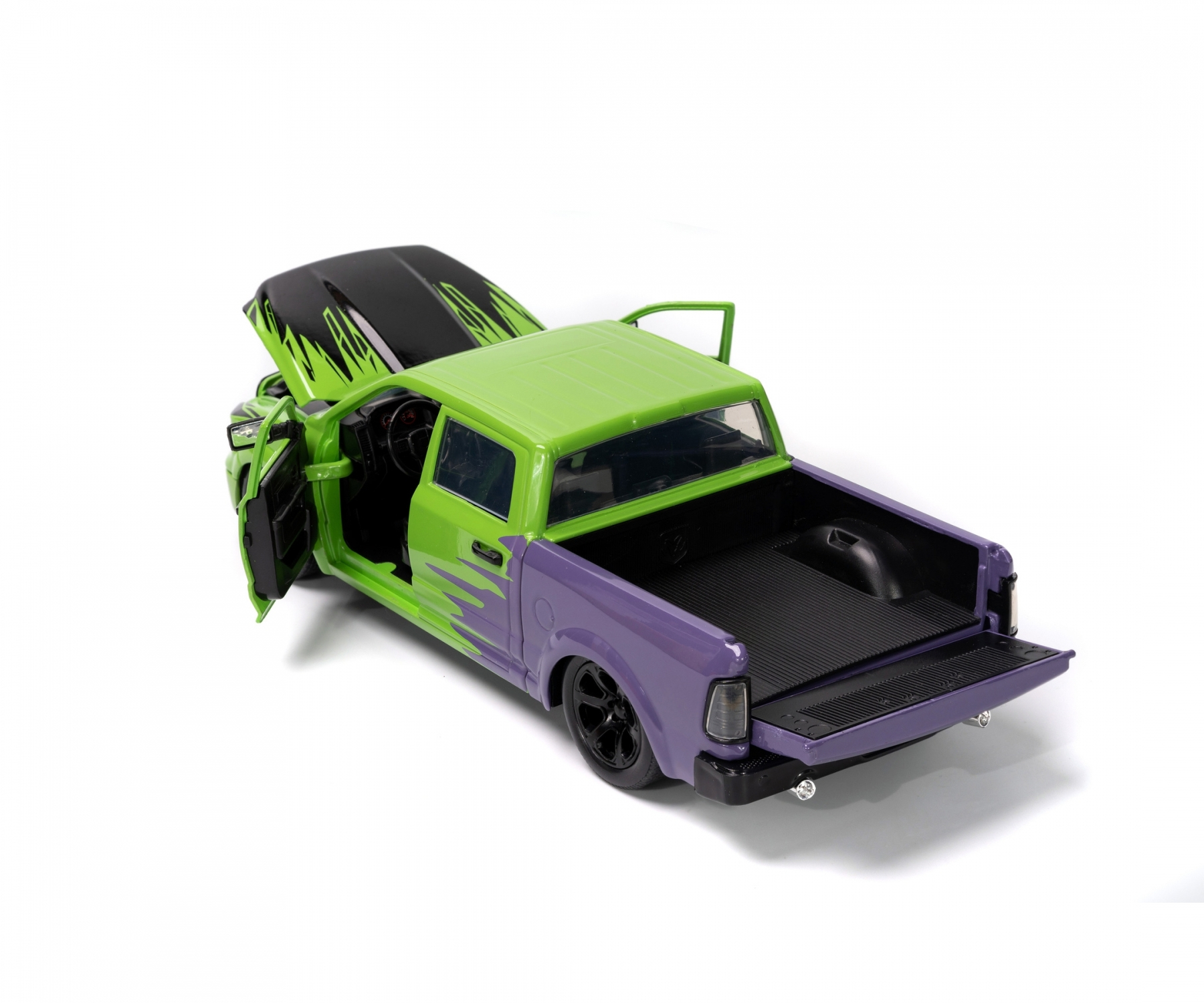 Camion jouet vert et violet avec capot ouvert, hayon et fond blanc.