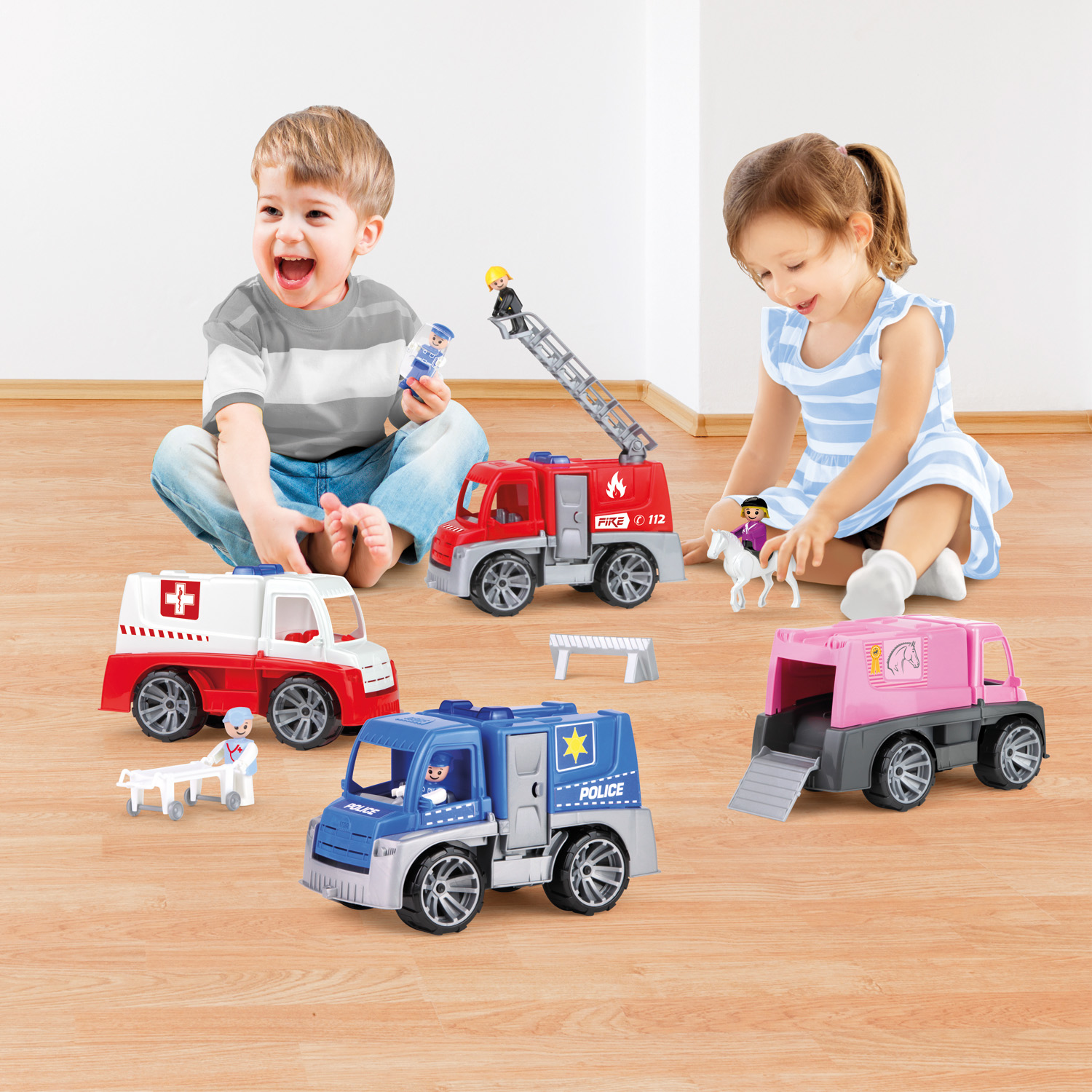 Due bambini che giocano con macchinine giocattolo. Include ambulanza, camion dei pompieri, auto della polizia e carrozza.