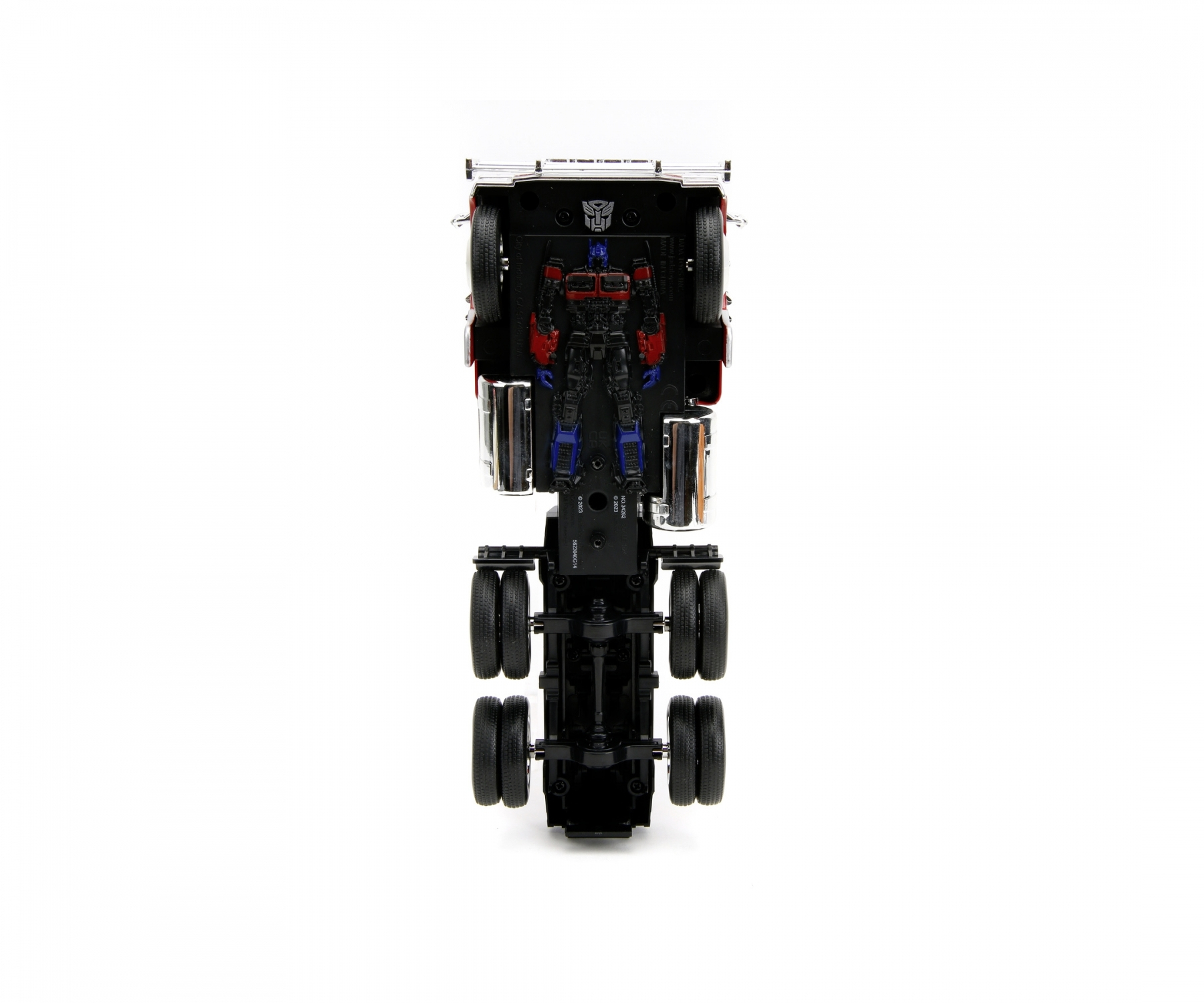 Spielzeug-LKW von oben, rotes und weißes Fahrerhaus, blauer Anhänger, mit einer Transformer-Figur.