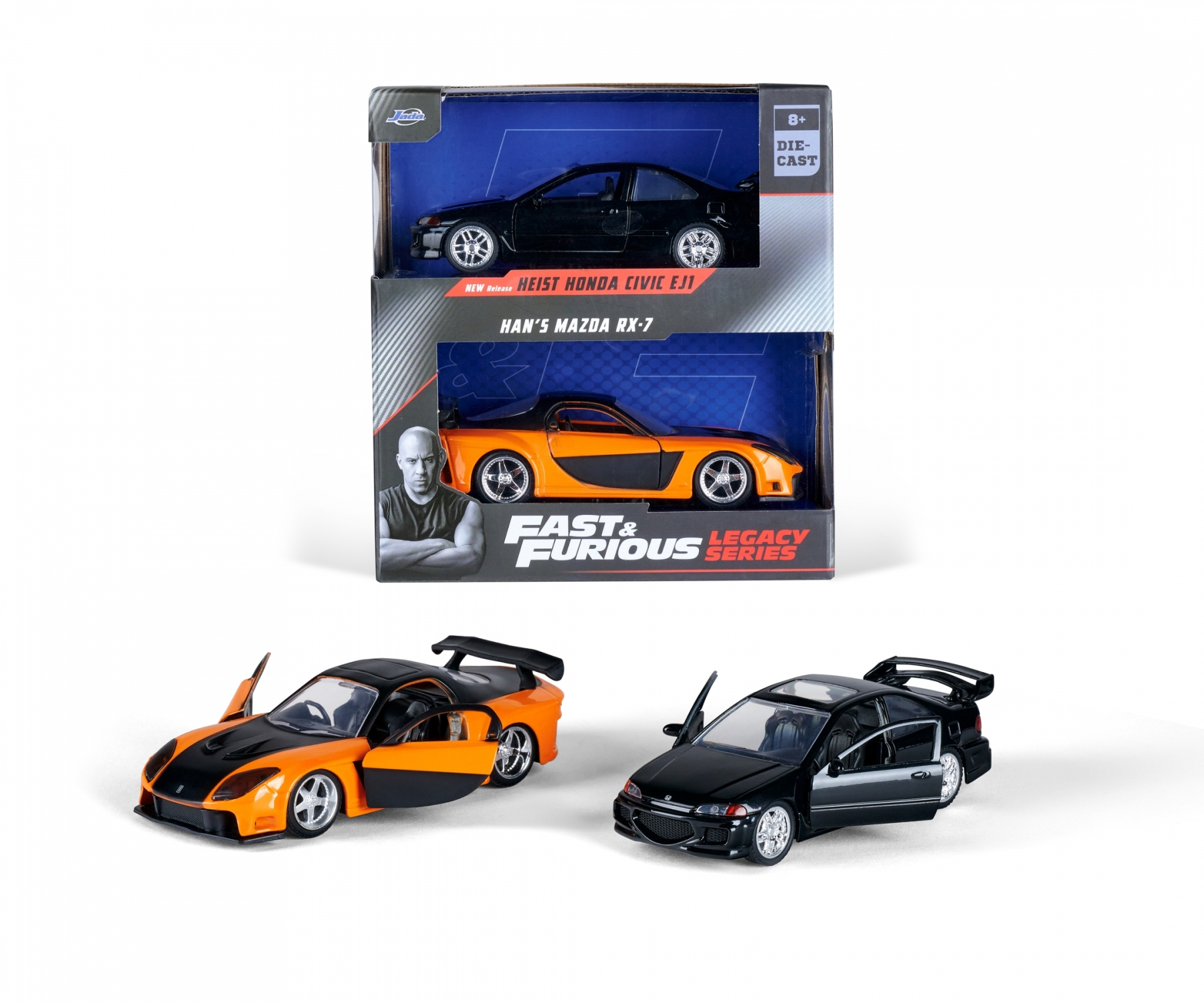 Spielzeugautos in Schachteln. Einer ist schwarz, der andere orange. Sie stehen auf weißem Grund.