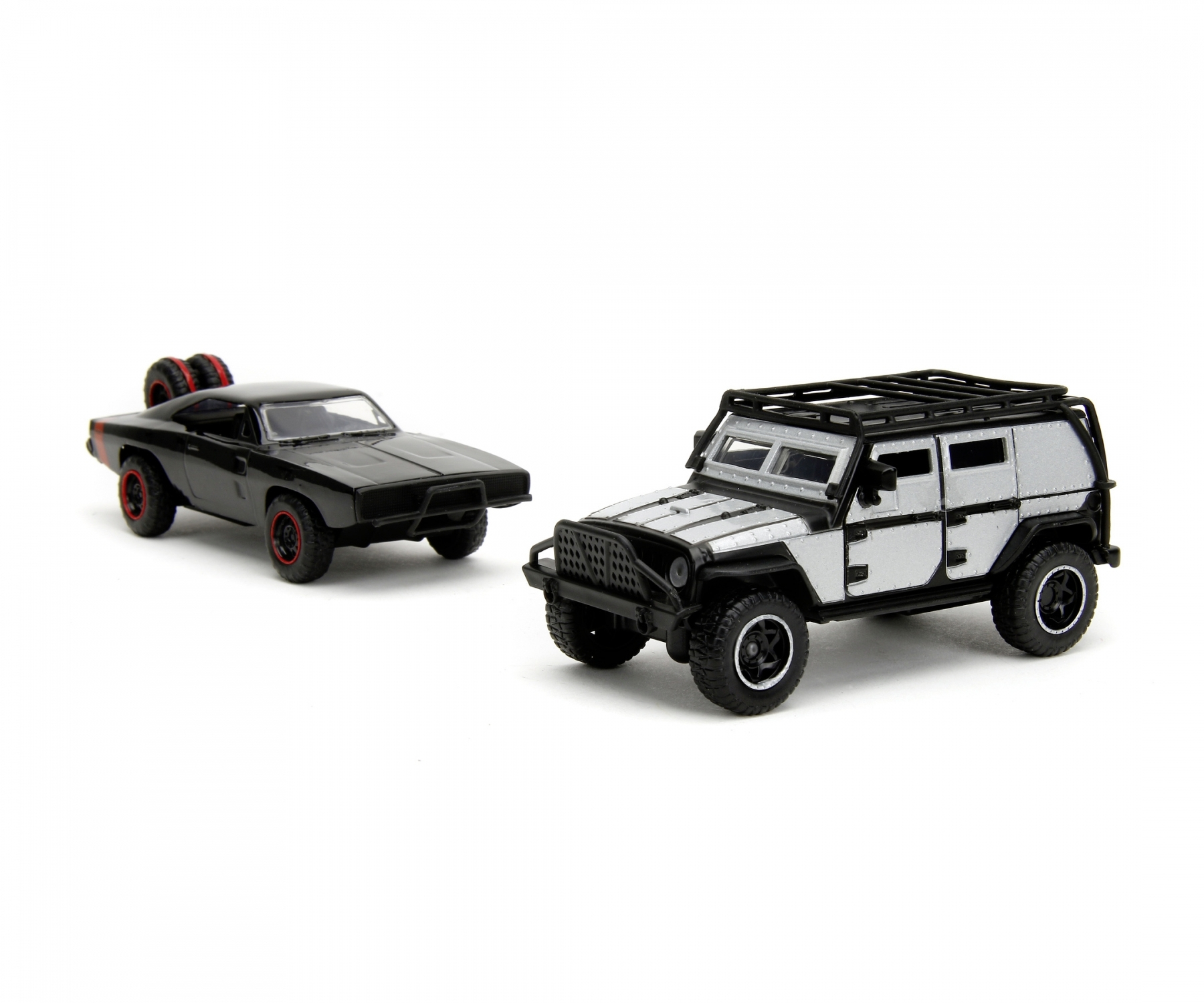 Zwei Spielzeugautos auf einer weißen Oberfläche. Eines ist ein schwarzer Muscle-Car, das andere ein silberner SUV.