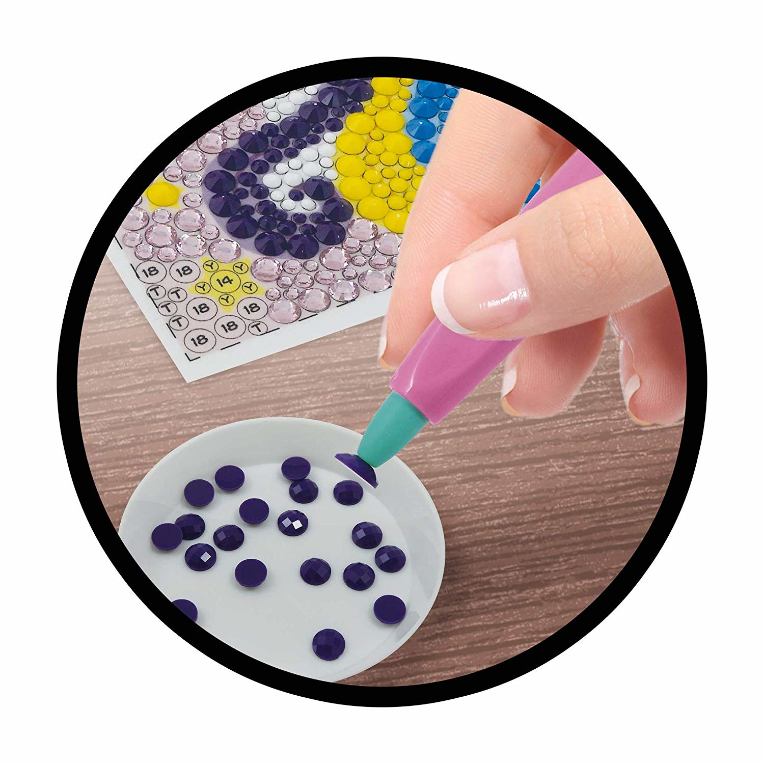 Zbliżenie dłoni umieszczającej fioletowy klejnot na malowaniu diamentami.