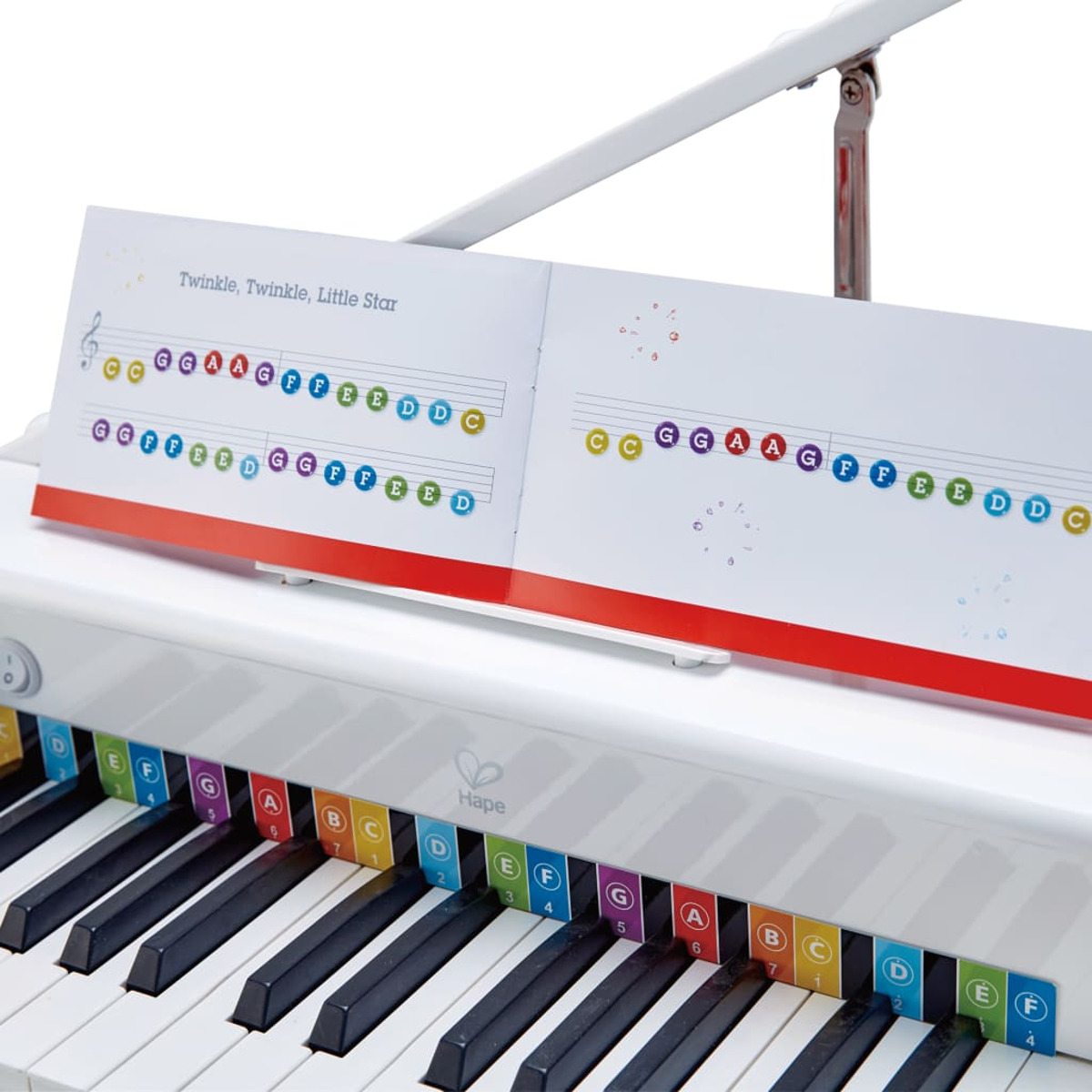 Białe zabawki pianino z kolorowymi klawiszami, nutami i literami.