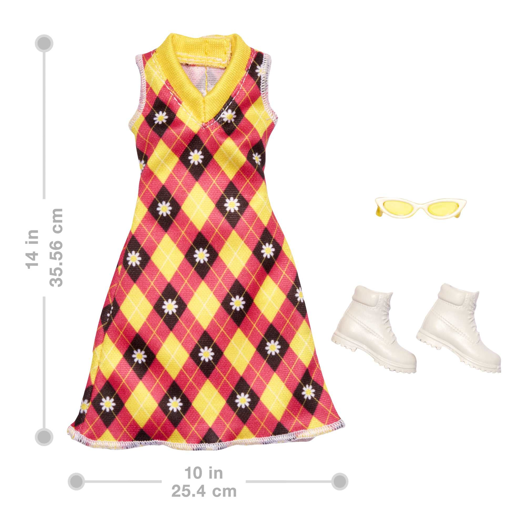 Sukienka z żółtymi i czerwonymi diamentami. Ma białe kwiaty i dekolt w kształcie litery V. Obok okulary przeciwsłoneczne i białe buty.