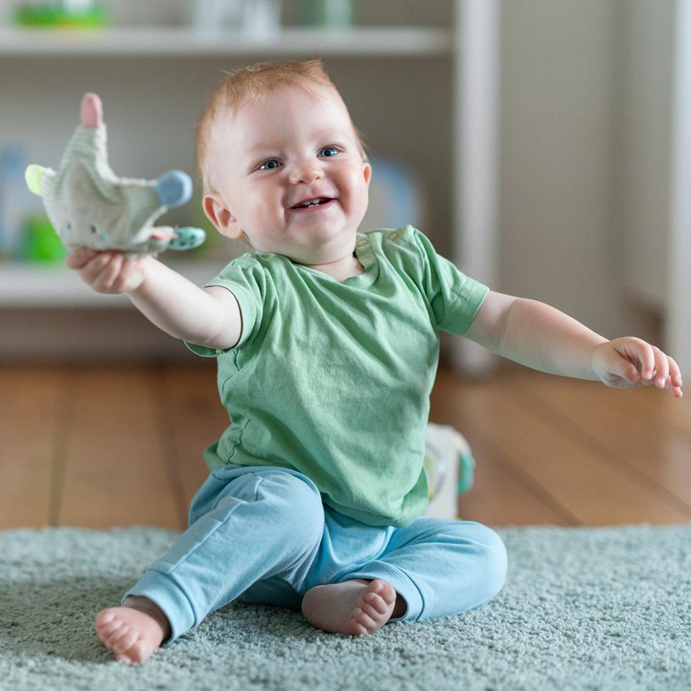 Uśmiechnięte dziecko trzymające zabawkę.