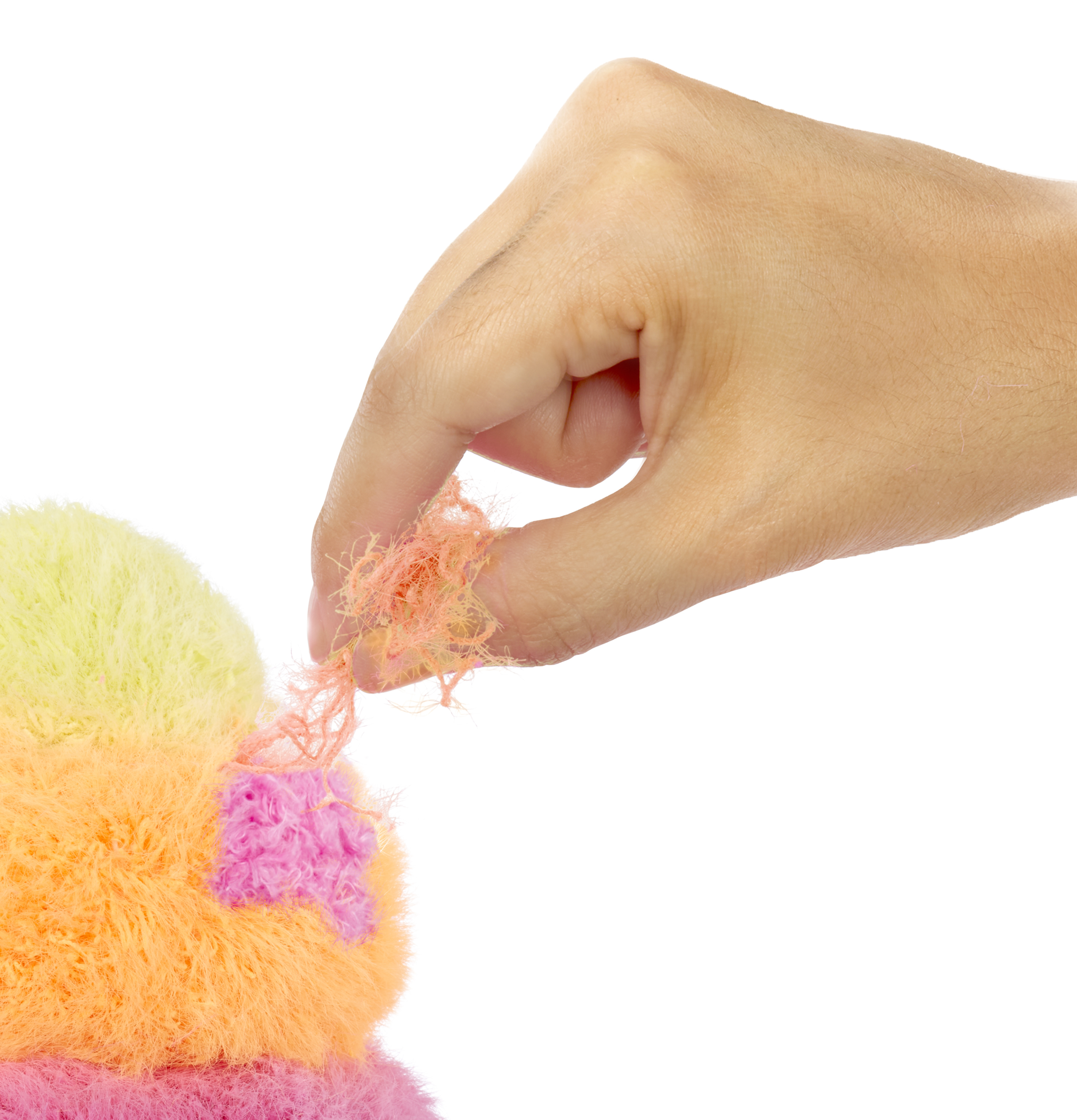 Ręka wyciąga pomarańczowe włókna pluszowej zabawki z zabawki.