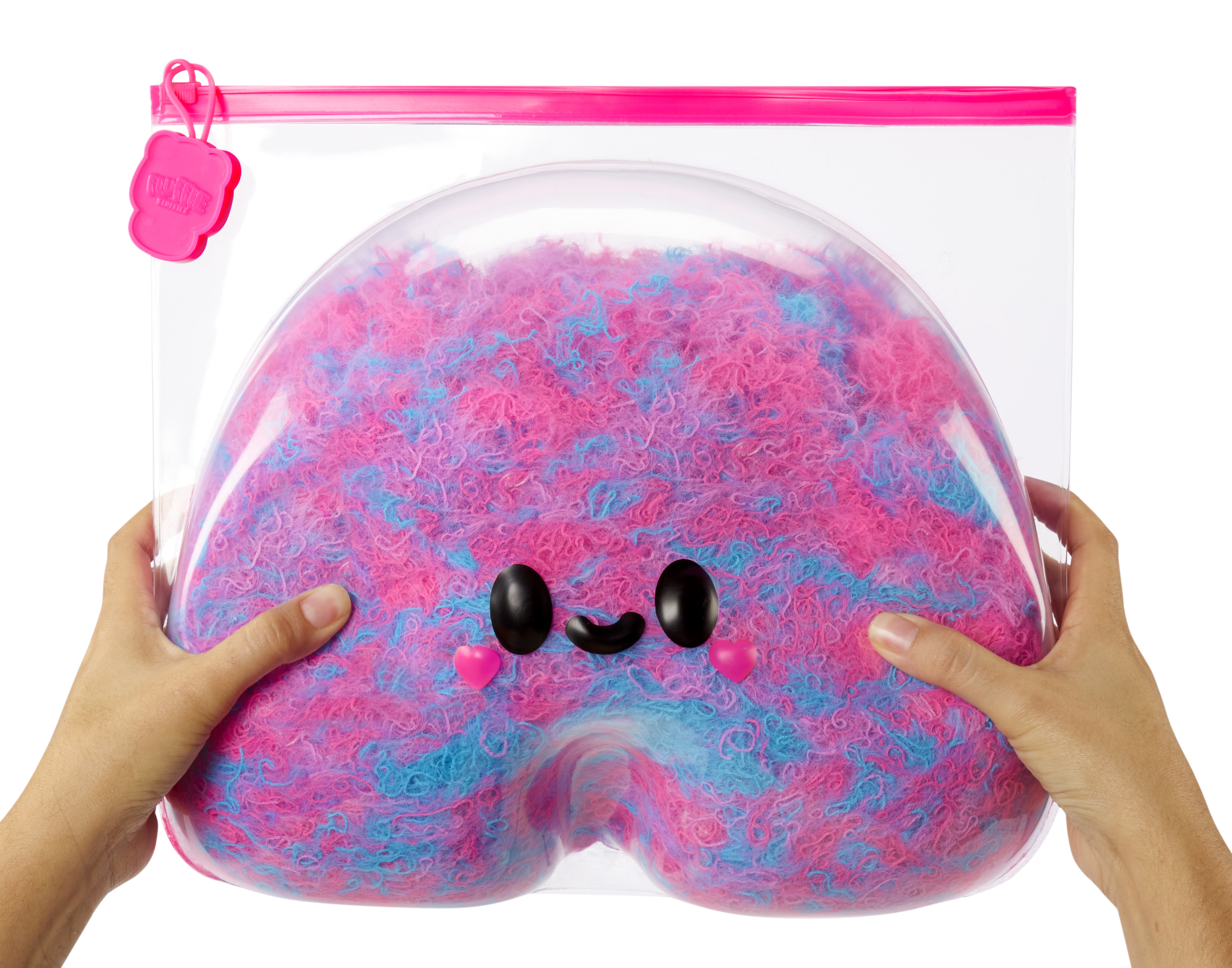 Dwie ręce trzymające przezroczystą torbę wypełnioną różowym i niebieskim puszystym materiałem.