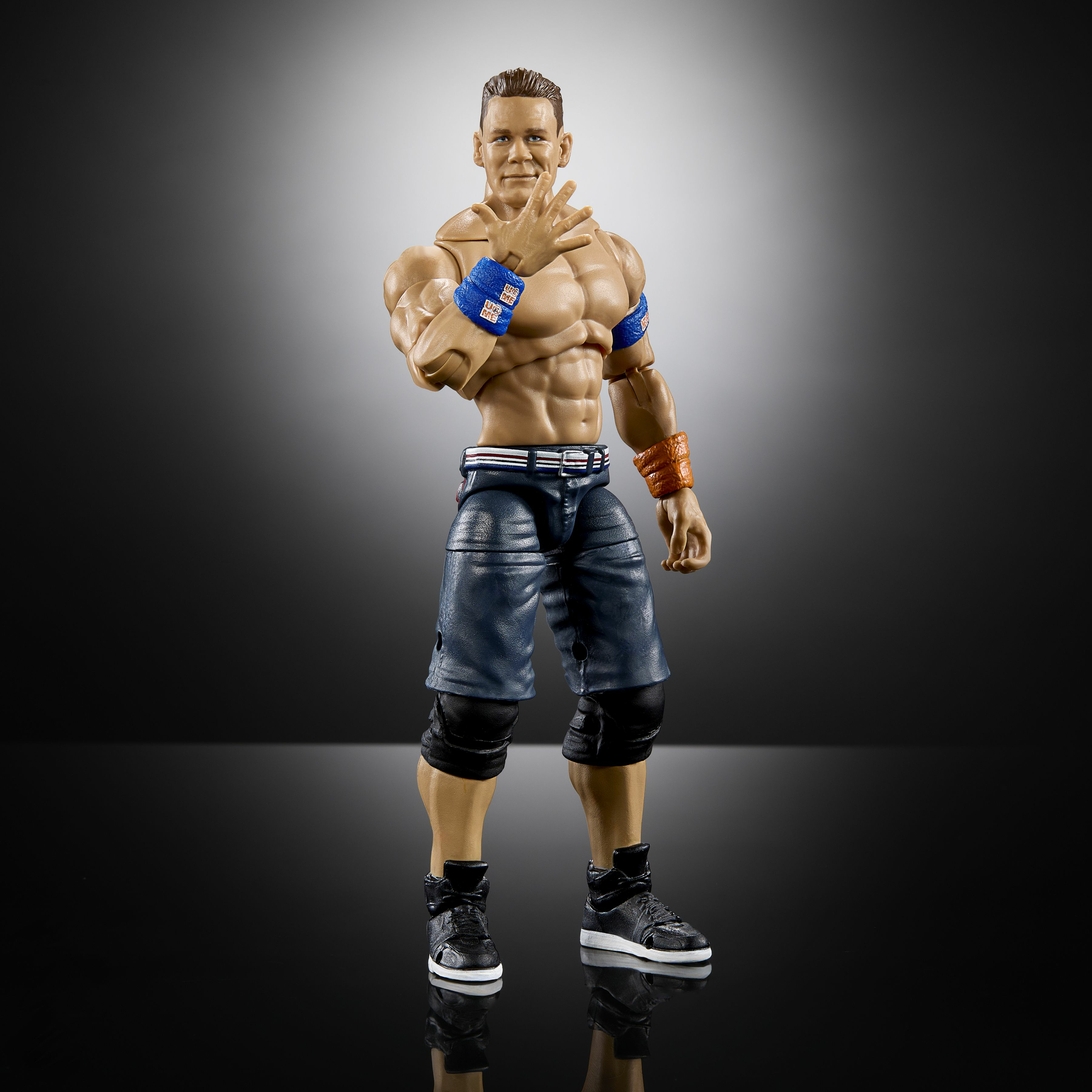 Un action figure di John Cena in posa da wrestling, a torso nudo con pantaloncini neri e blu.