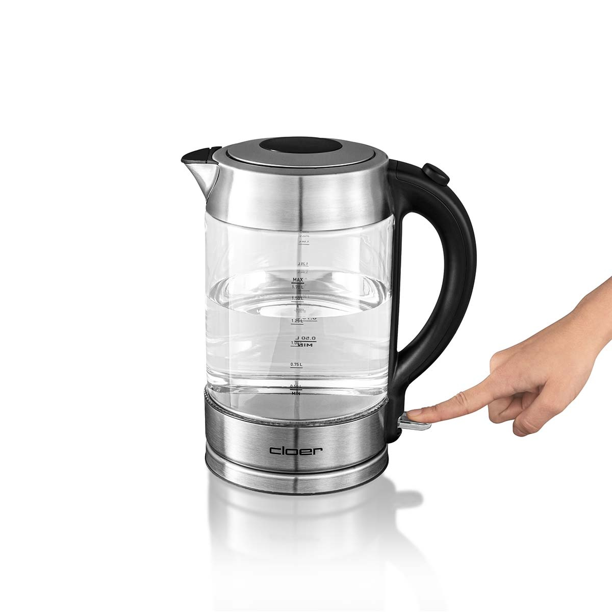 Szklany czajnik elektryczny z wodą w środku. Ręka naciska przycisk zasilania. Białe tło.