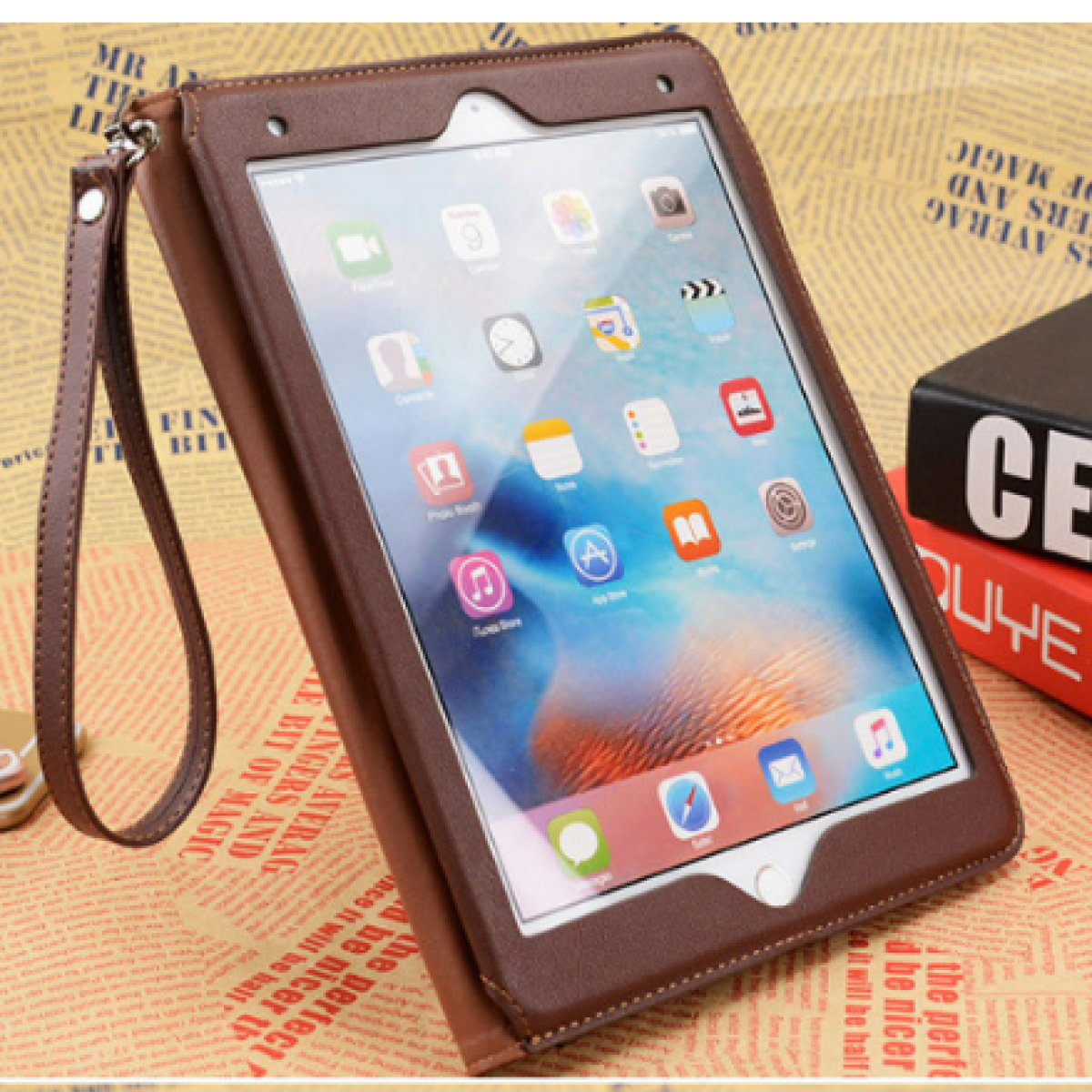 Custodia per tablet marrone con tablet all'interno. È attaccato un cinturino. Sfondo beige.