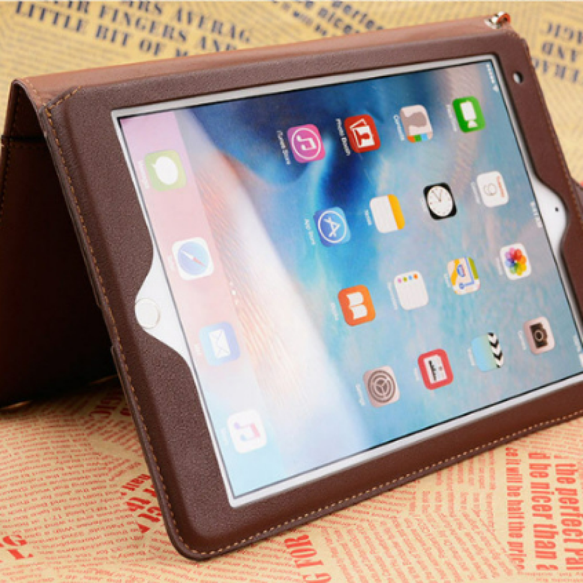 Tablet in una custodia marrone su sfondo di giornale.