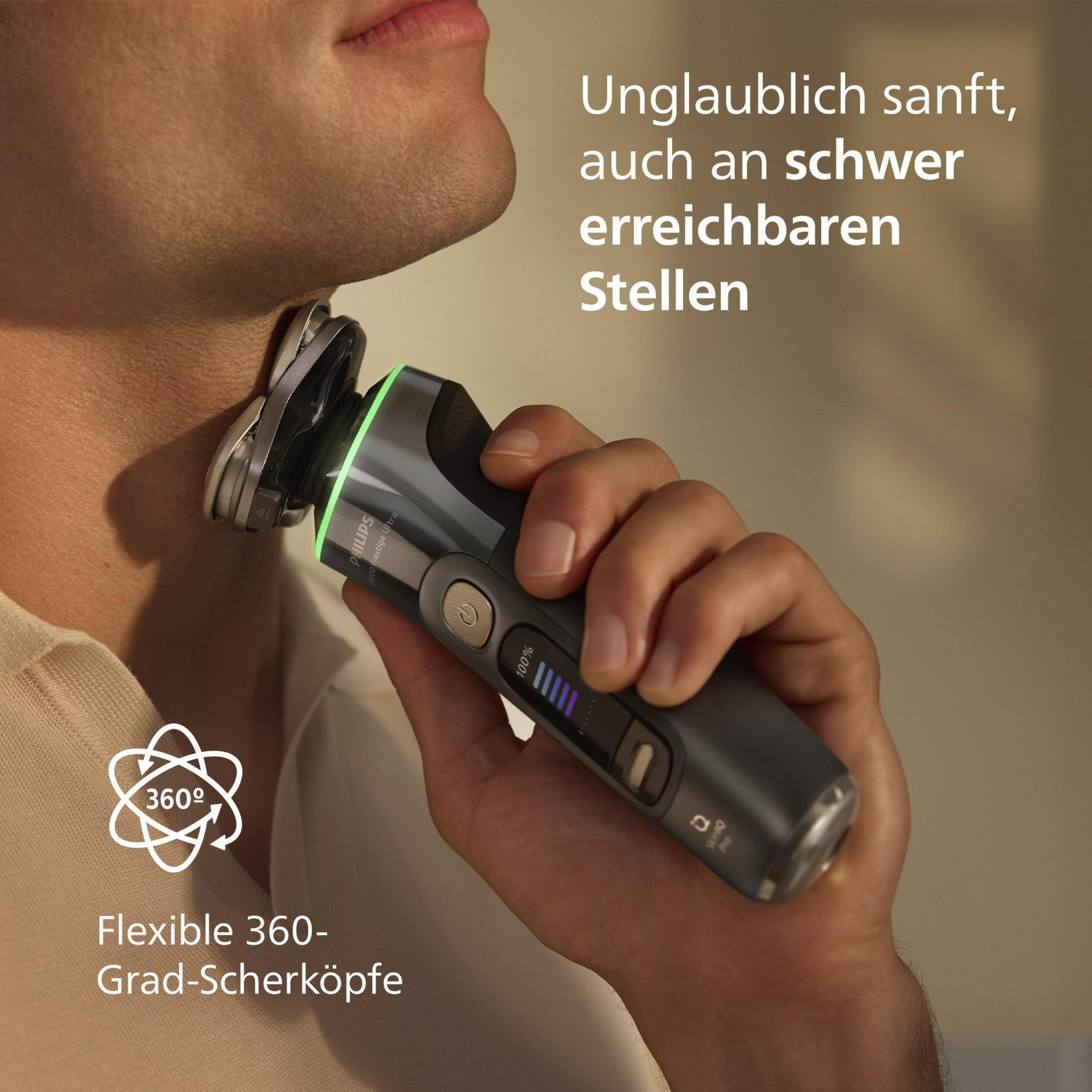 Uomo che si rade con Philips Prestige Ultra. Rasoio con testine dorate e display digitale del livello batteria.