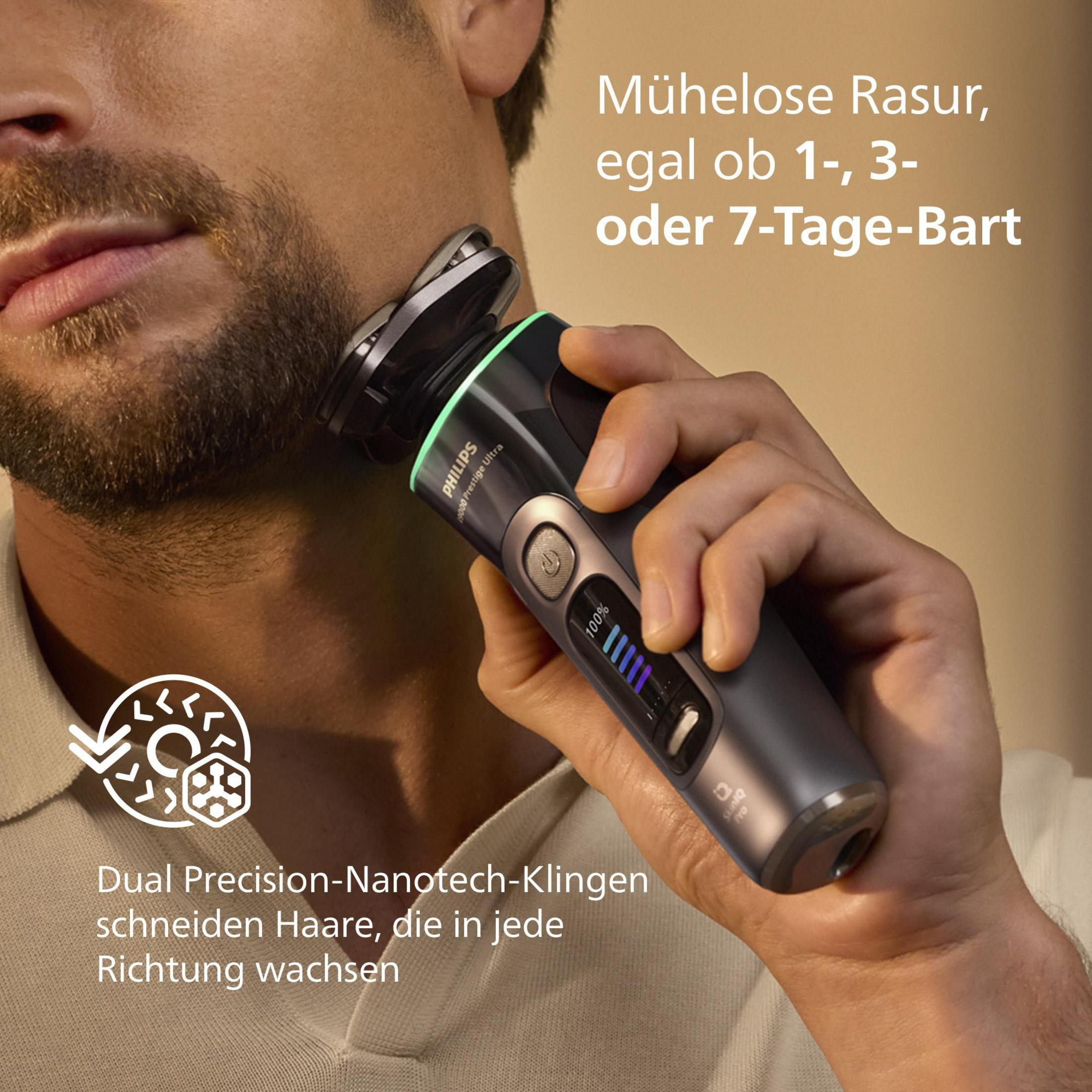 Uomo che si rade con Philips Prestige Ultra. Primo piano mostra rasoio con testine dorate. Pelle mostra 100% batteria.