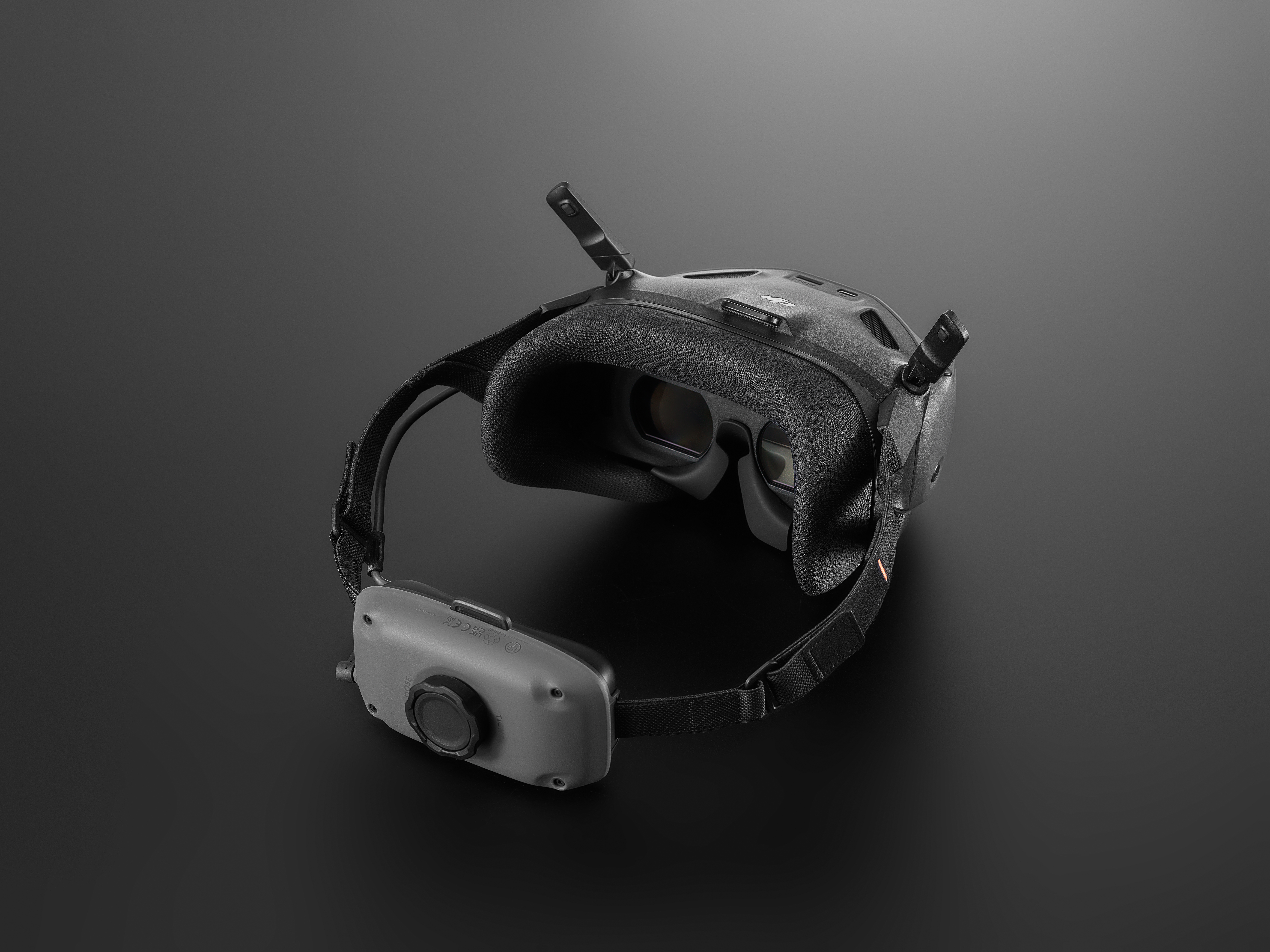 Visore VR dalla parte posteriore. Le cuffie sono nere, il cinturino è sul retro. Sfondo nero.