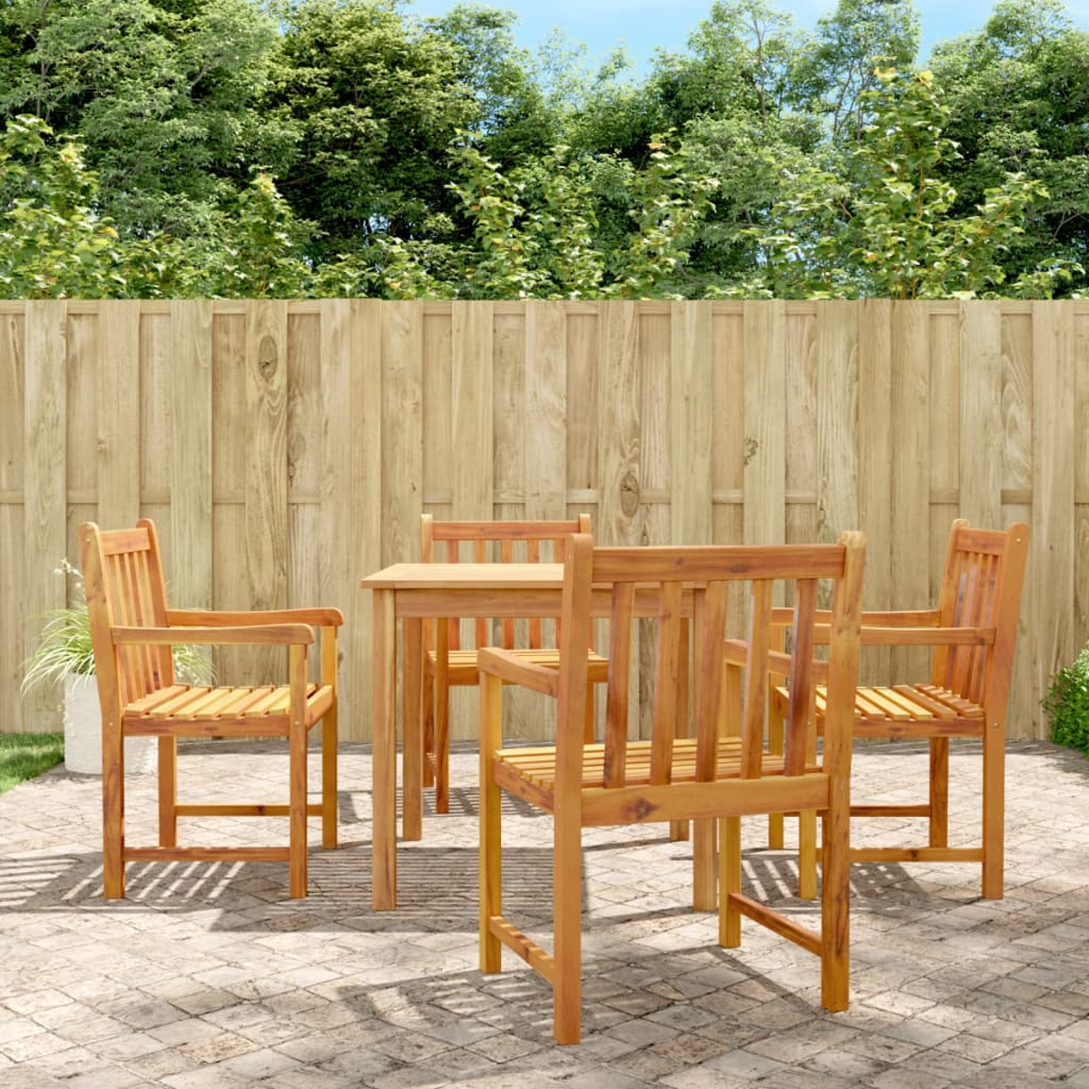 Essgruppe aus Holz im Freien mit Tisch und Stühlen auf einer Ziegelterrasse. Grüner Hintergrund.