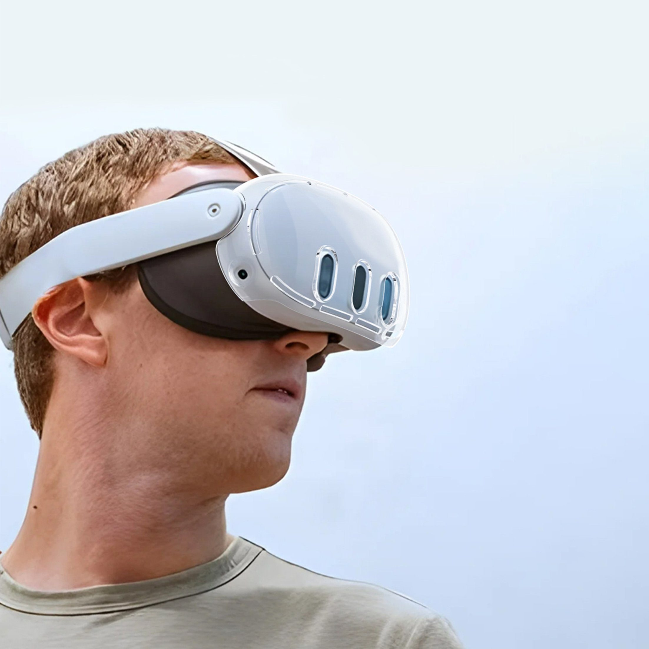 Mann trägt VR-Headset, blickt nach links. Hellblauer Himmel. Weißes Headset mit drei Linsen. Mann trägt grünes Hemd.
