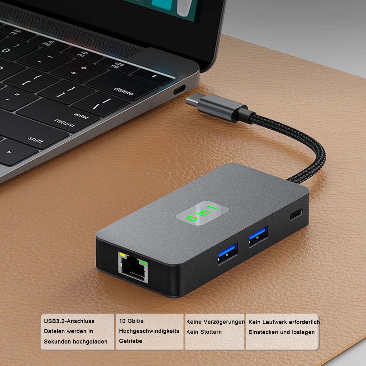 Ein grauer 6-in-1-USB-Hub, der mit einem Laptop verbunden ist. Der Hub ist auf braunem Untergrund.