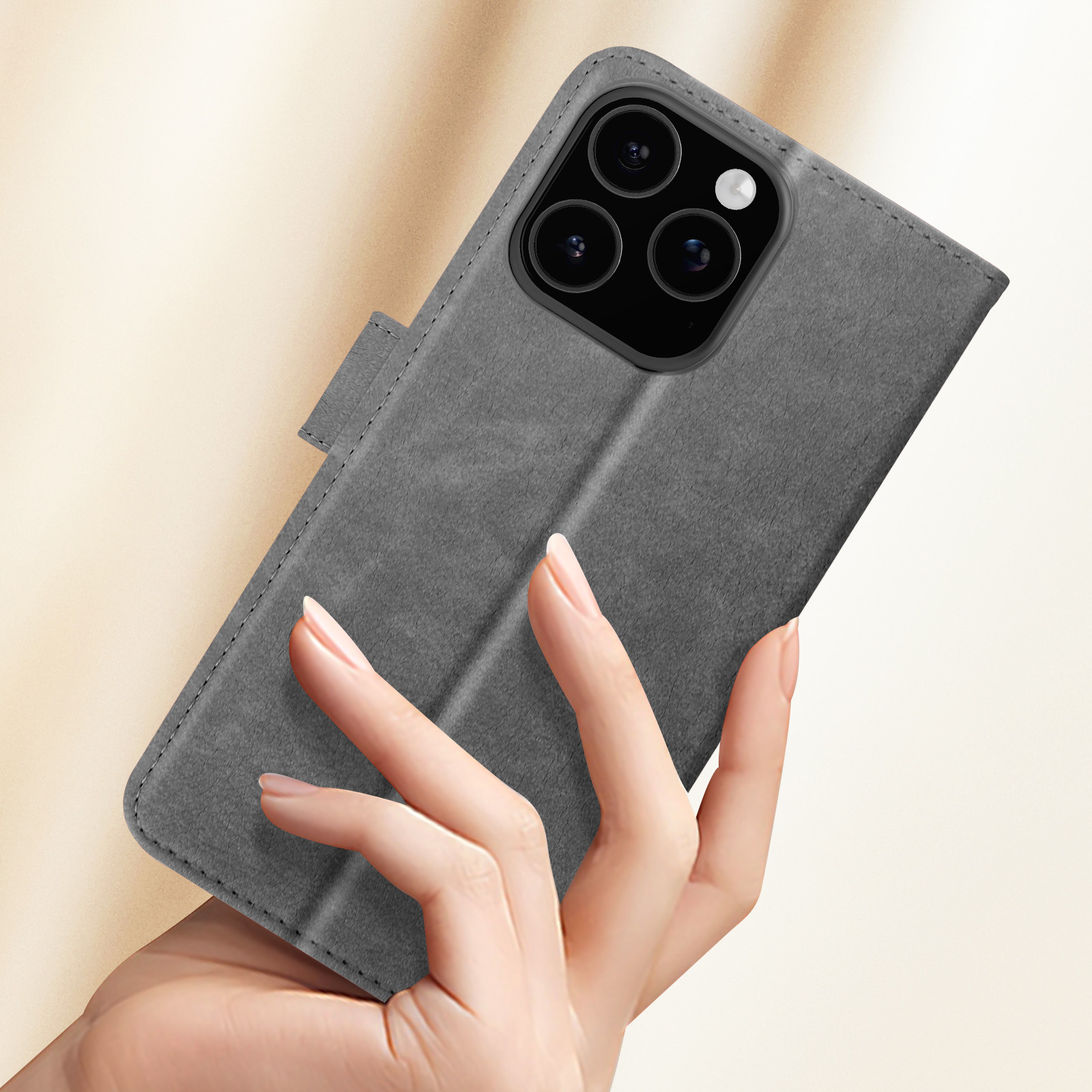 Mano che tiene una custodia grigia per telefono, che mostra la cover frontale chiusa. Sfondo sfocato.