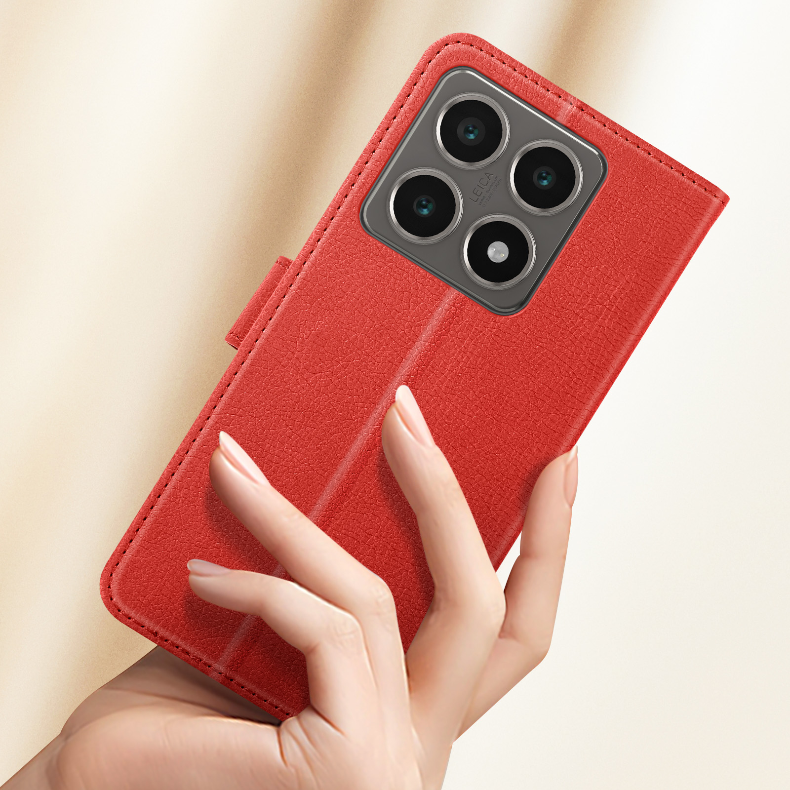 Una mano che tiene una custodia rossa per telefono con il telefono all'interno. Le lenti della fotocamera sono visibili.
