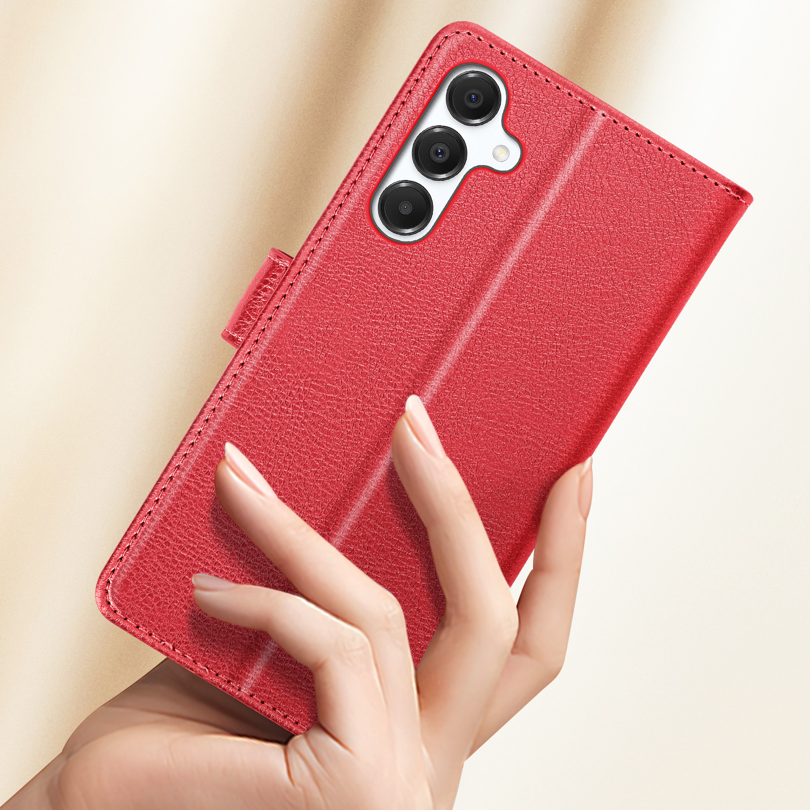 Una mano tiene una custodia rossa per telefono. La custodia è chiusa e le fotocamere del telefono sono visibili.