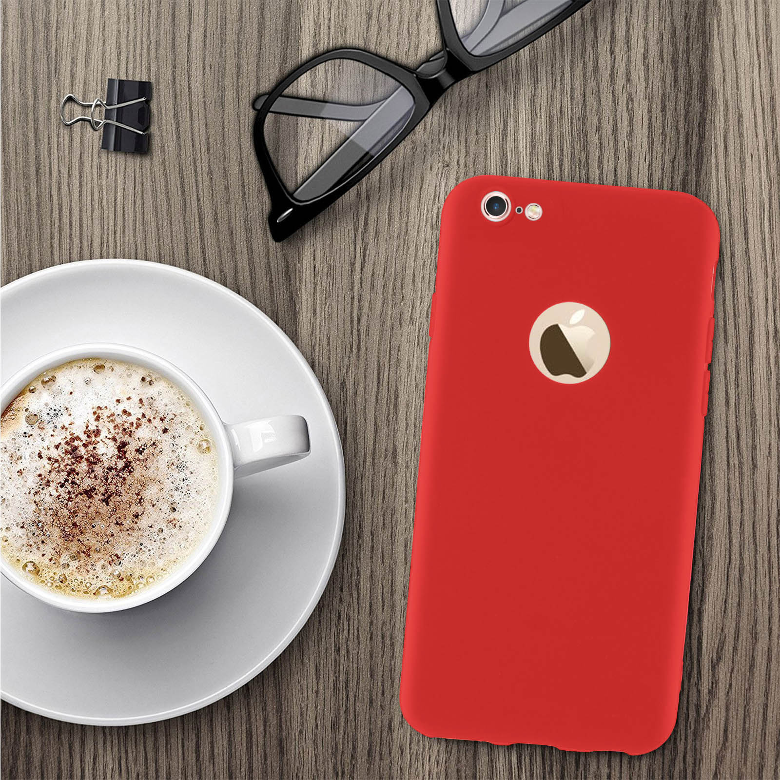 iPhone rojo sobre mesa de madera con café y gafas. Gafas negras sobre la mesa.