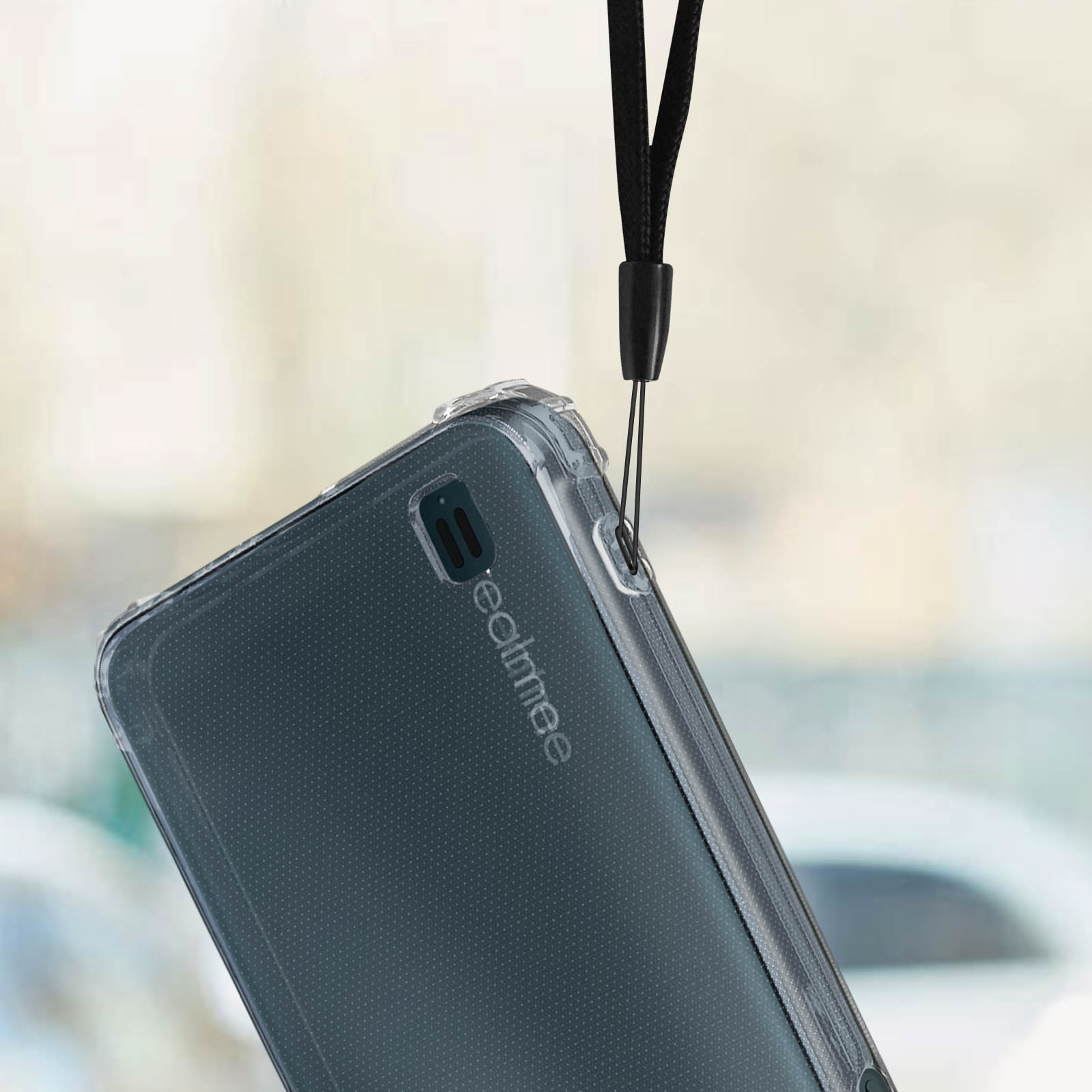Telefono con custodia trasparente e cinturino nero, tenuto su sfondo sfocato.