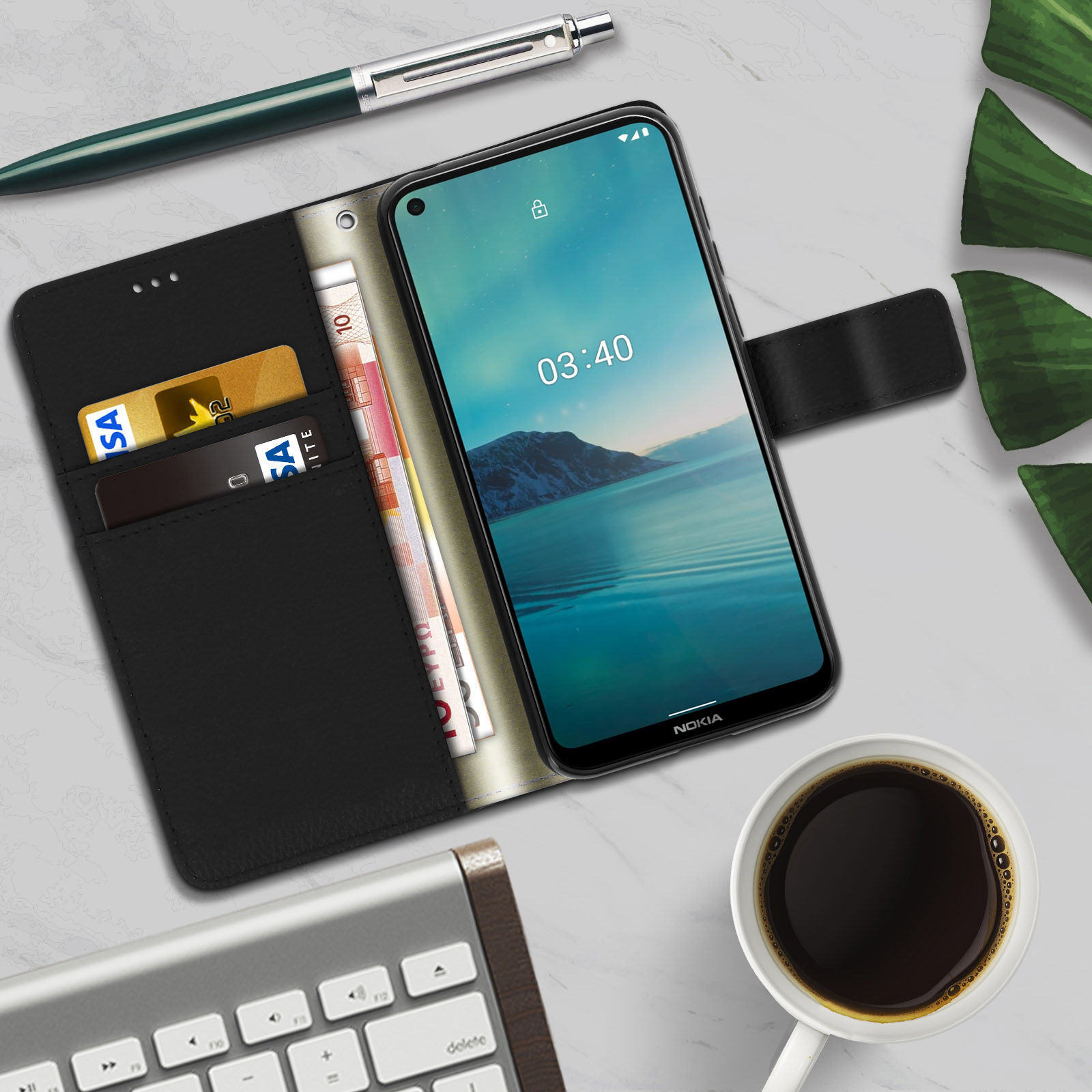 Telefono in custodia nera aperta con carte e denaro, con caffè e penna su un tavolo.