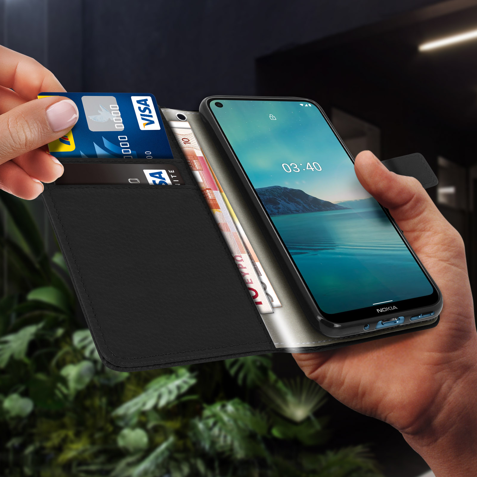 Mano che tiene telefono, portafoglio e carta con soldi e carta di credito.
