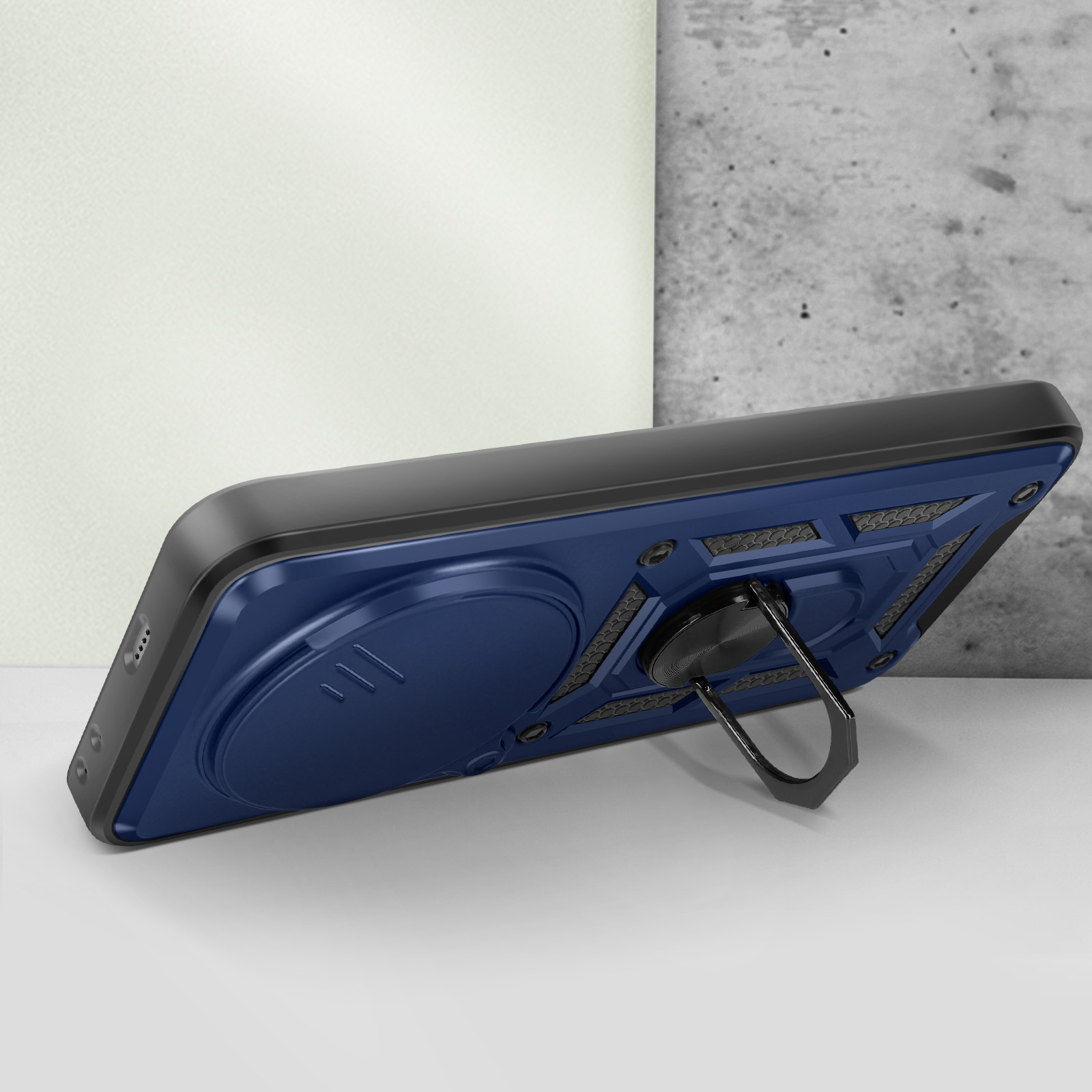 Custodia blu con supporto ad anello, su una superficie. Sfondo bianco e cemento.