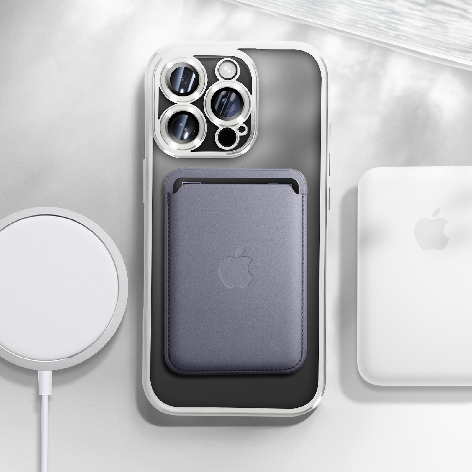 iPhone con custodia trasparente, accessori MagSafe. Portafoglio e base di ricarica visibili.