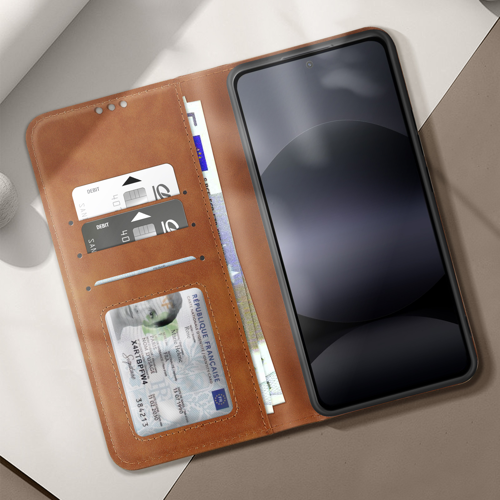 Custodia per telefono in pelle marrone aperta con telefono, carte e denaro all'interno.