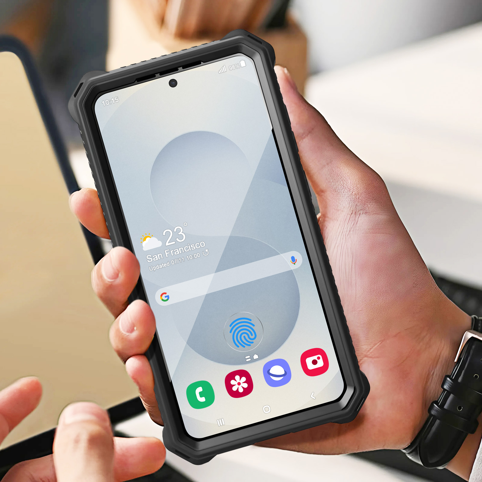 Mano che tiene un telefono con custodia nera, che mostra lo schermo. Icona dell'impronta digitale visibile.
