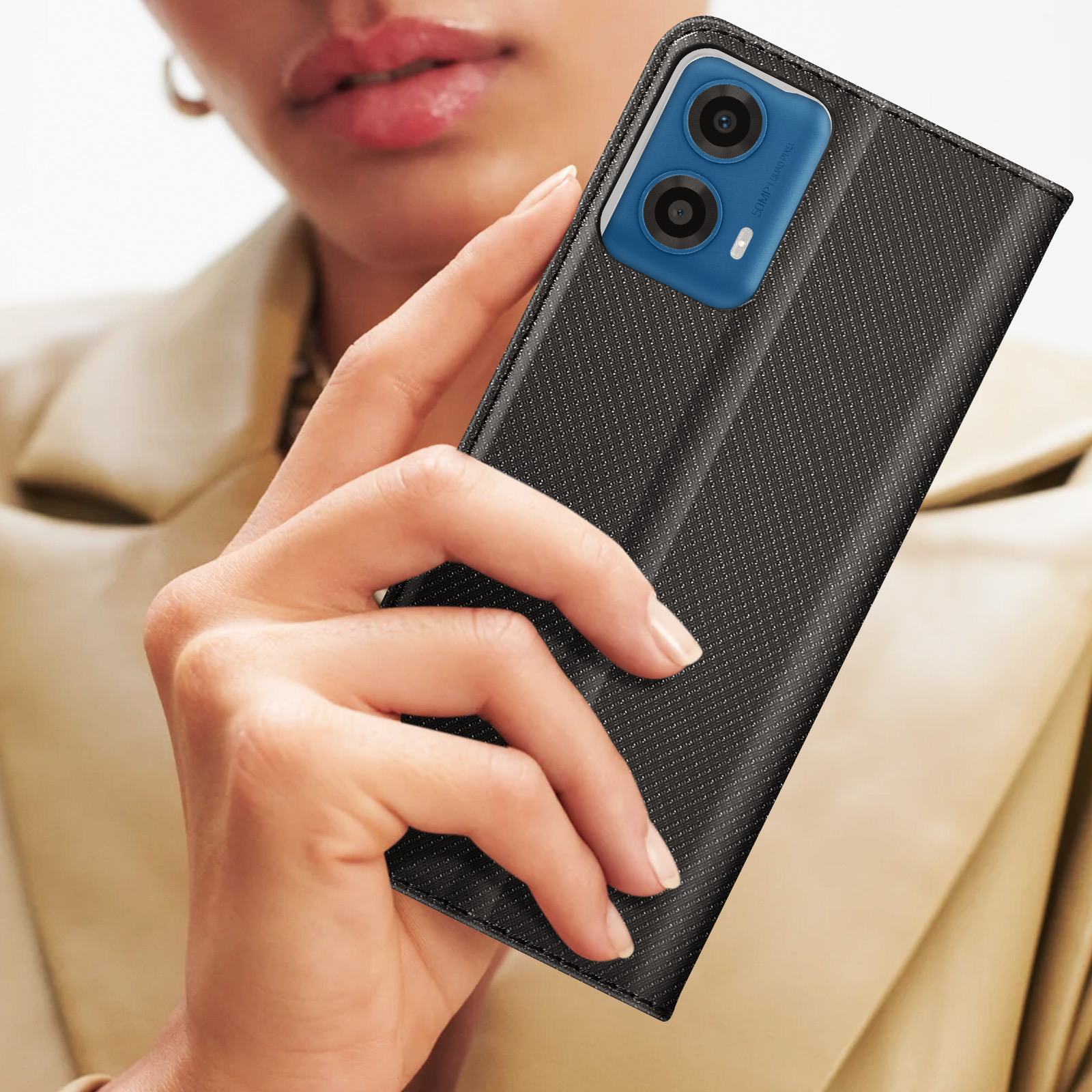 Una donna che tiene in mano una custodia per telefono nera con un telefono all'interno. Sfondo beige.