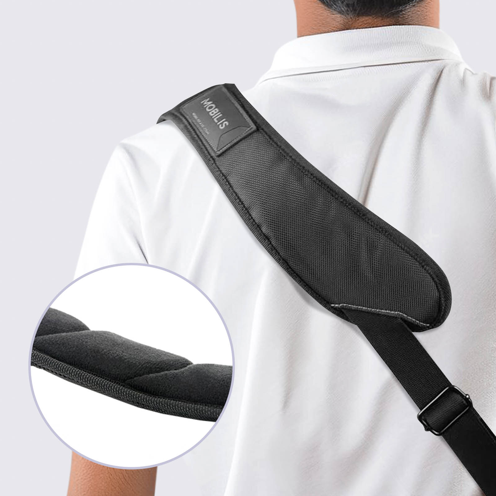 Tracolla nera con imbottitura, indossata da persona in camicia bianca. Dettaglio dell'imbottitura.