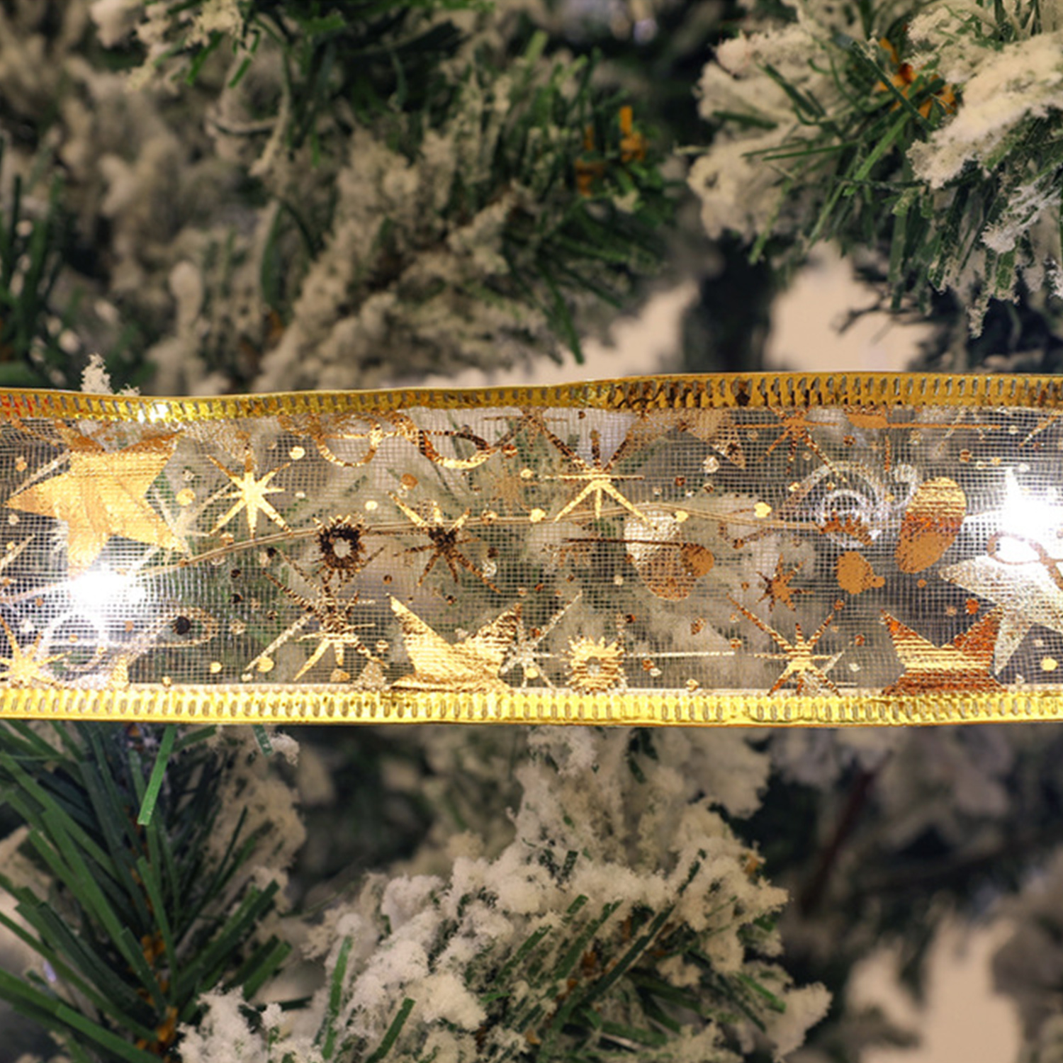 Nahaufnahme eines Weihnachtsbaum-Bandes mit goldenen Sternen und Schneeflocken.