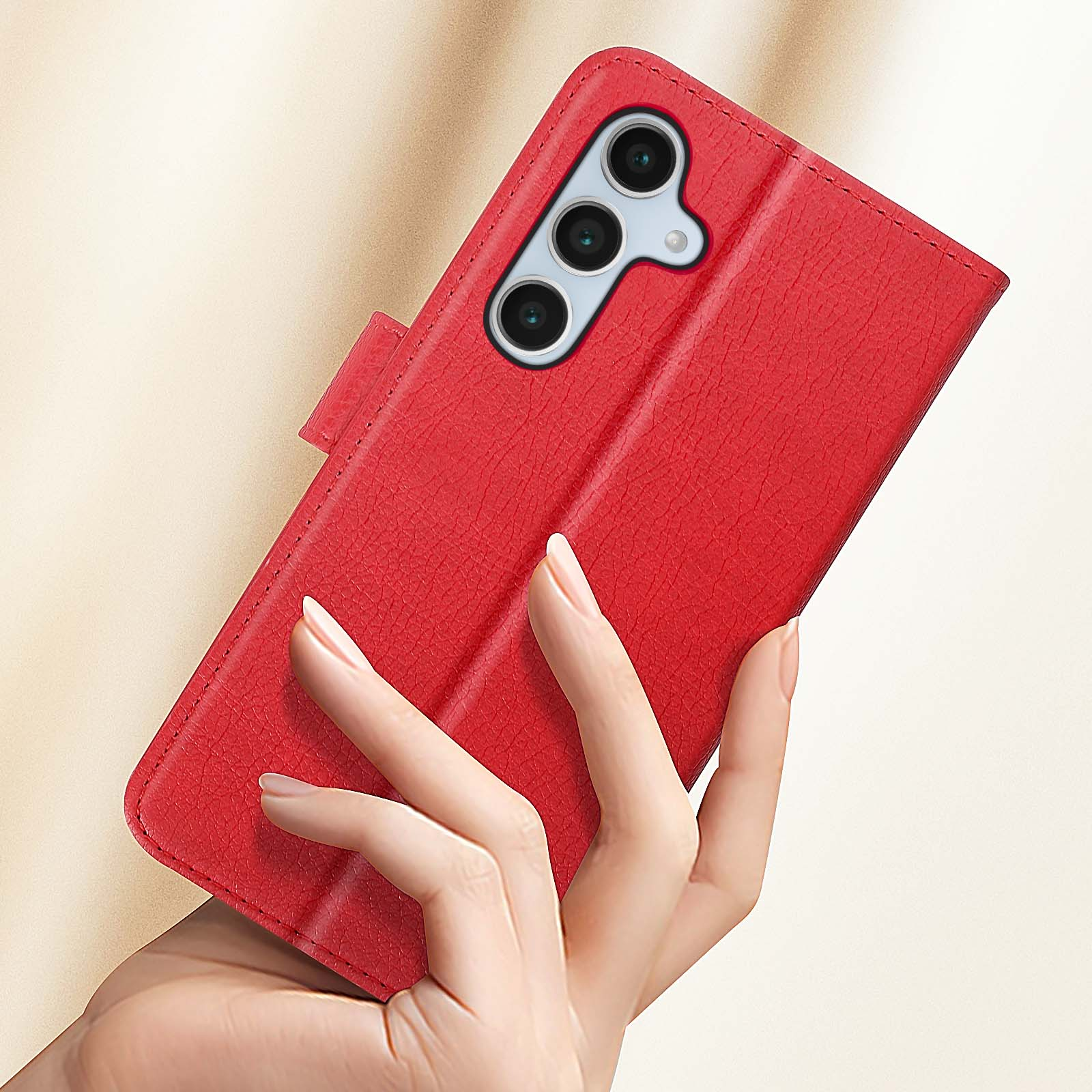 Mano che tiene una custodia rossa per telefono. Un telefono con tre fotocamere è visibile. La custodia è aperta.