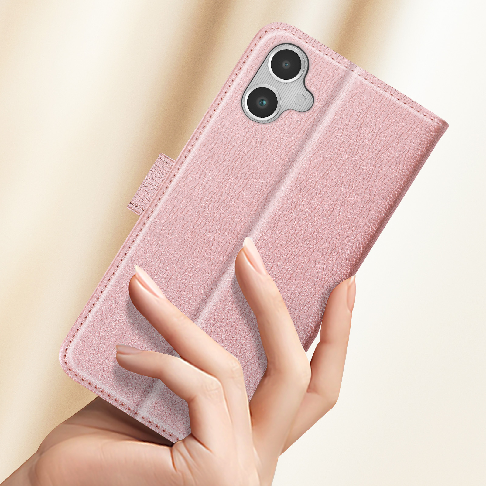 Mano che tiene una custodia rosa aperta per telefono. Il telefono è visibile. Lo sfondo è sfocato.