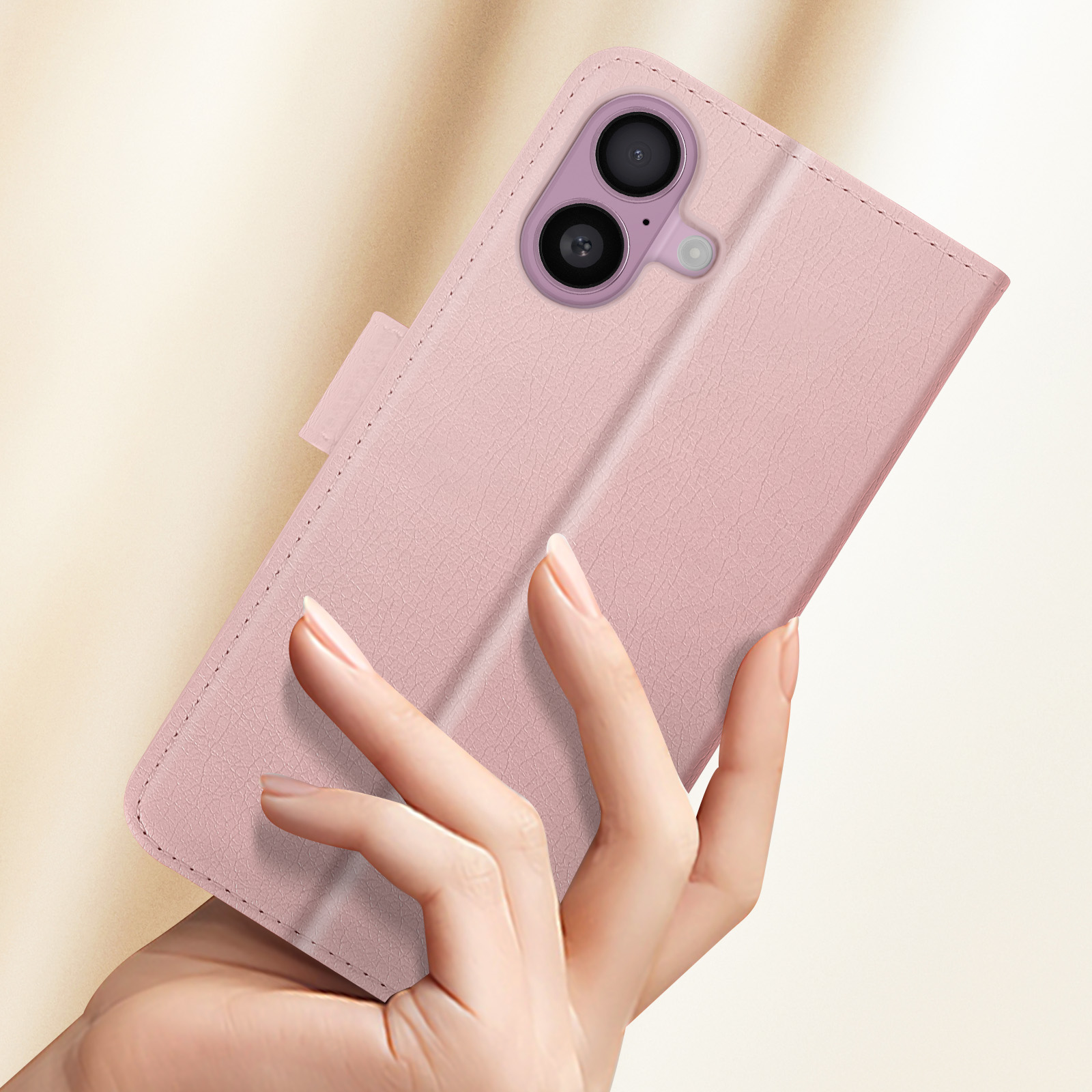Custodia rosa per telefono aperta in una mano. La custodia è in primo piano, lo sfondo sfocato.