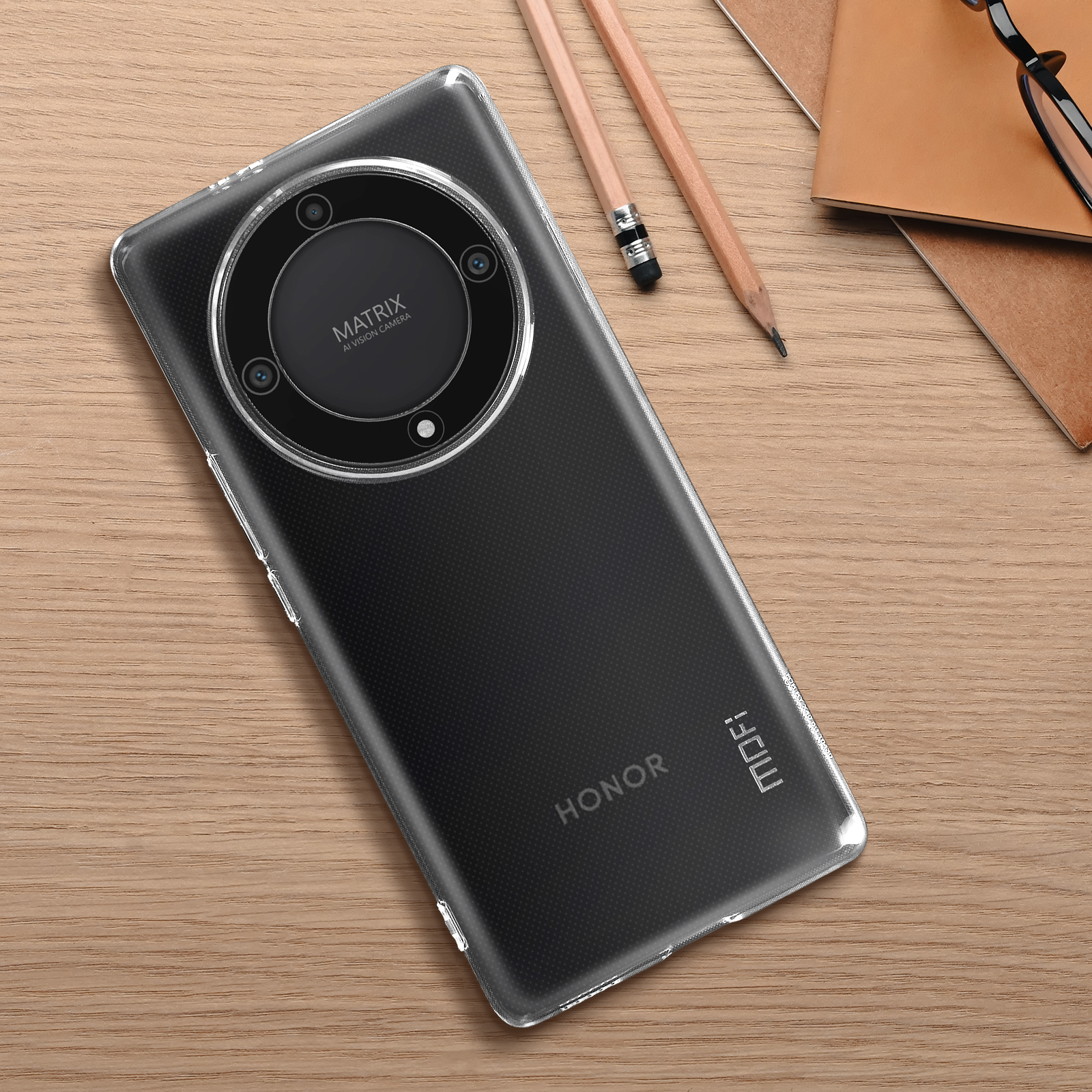Una custodia trasparente per telefono su una superficie di legno. Una matita e un taccuino sono accanto. Il telefono ha un array di fotocamere.