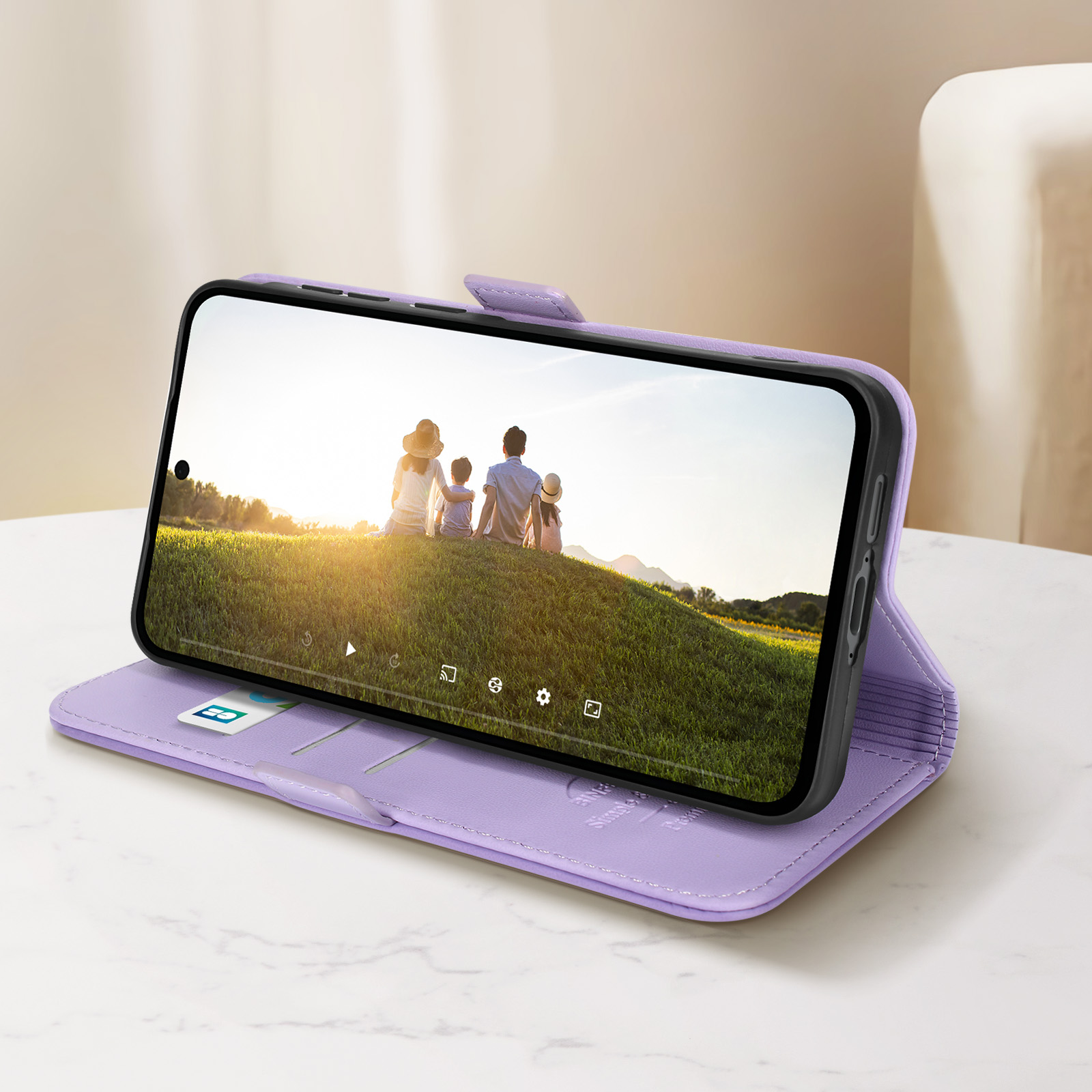 Custodia per telefono lilla aperta, che mostra una famiglia su una collina erbosa sullo schermo del telefono. Sfondo bianco.