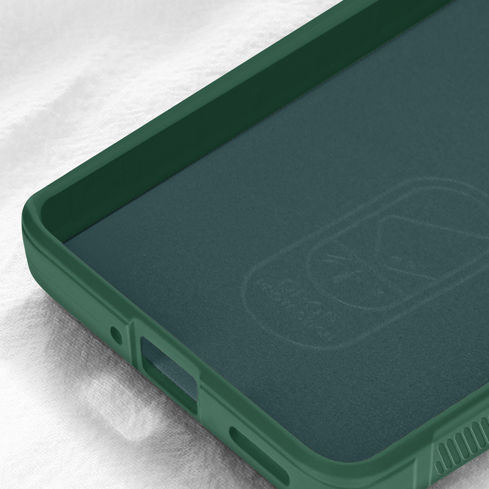 Interno di una custodia verde per telefono. L'interno è verde scuro. La custodia è su una superficie bianca strutturata.