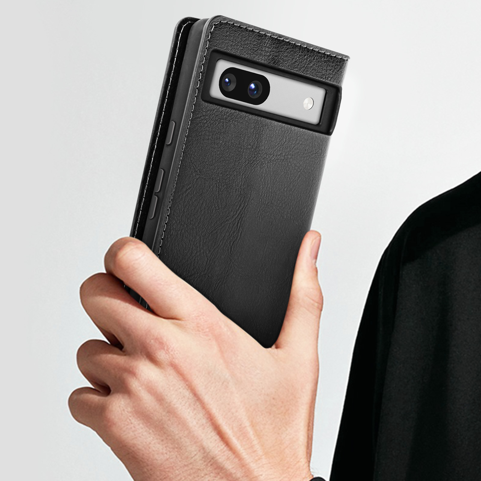 Una persona tiene in mano un telefono nero in una custodia nera. Il telefono è visibile.