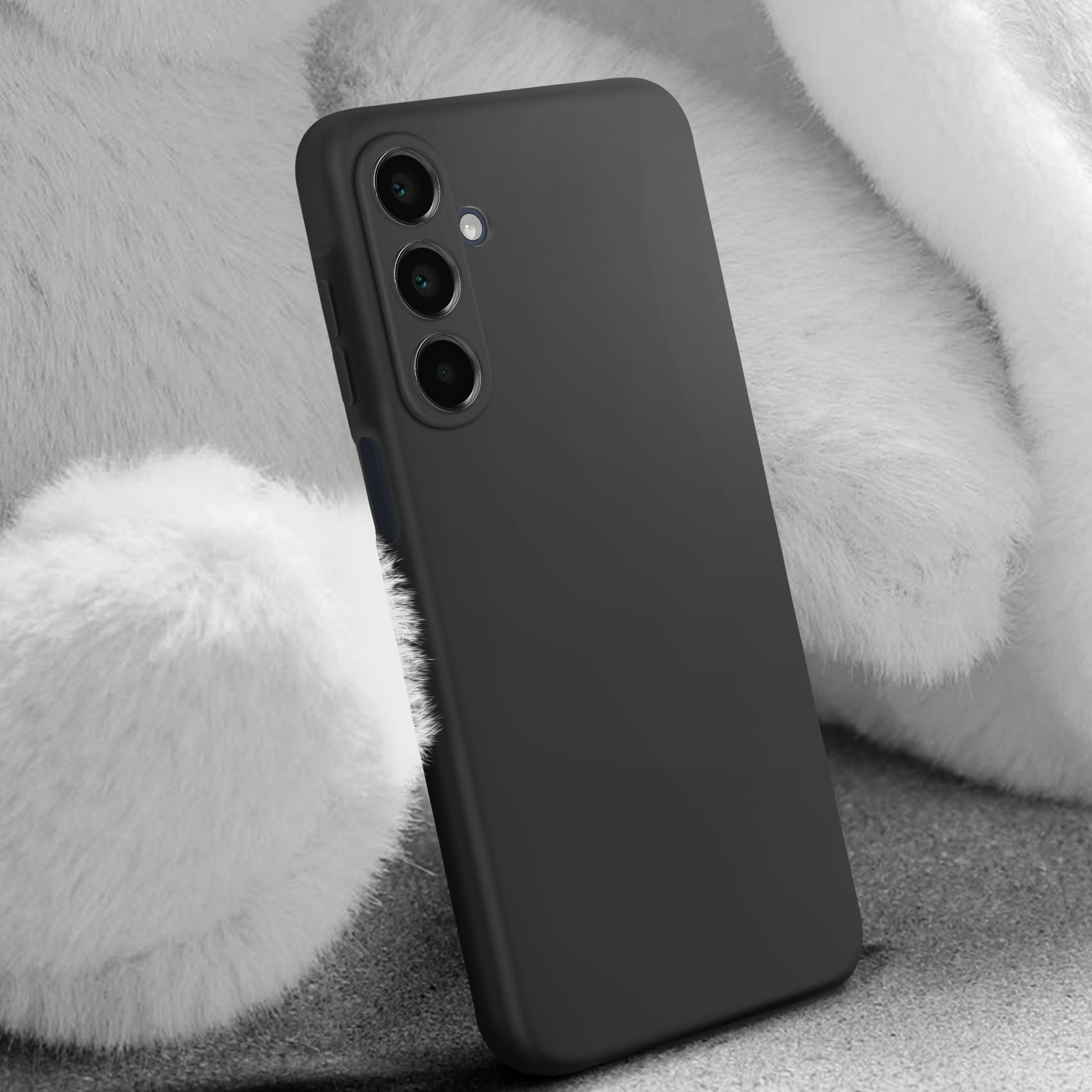 Custodia nera per telefono, appoggiata su una superficie bianca e morbida. Tre obiettivi della fotocamera sono visibili.